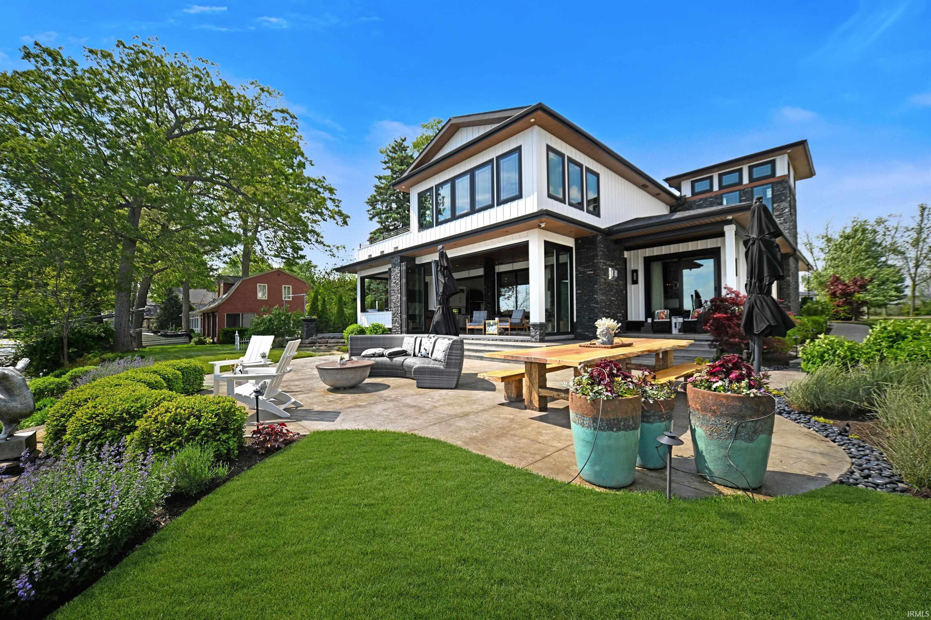 Modern exterior featuring white siding, dark stone accents, and black-framed windows