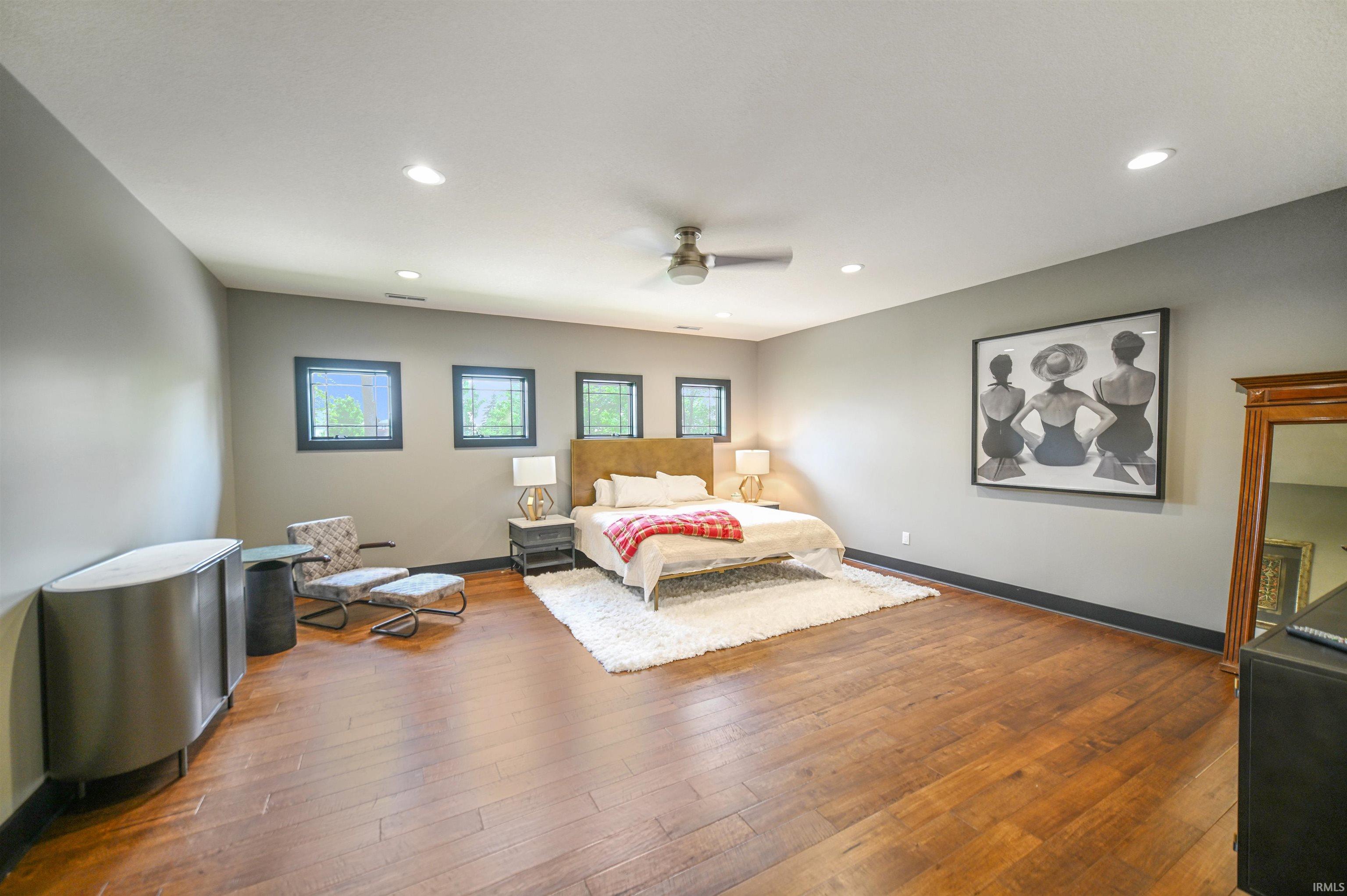 Spacious interior room featuring wood-finish flooring, recessed lighting, and a ceiling fan