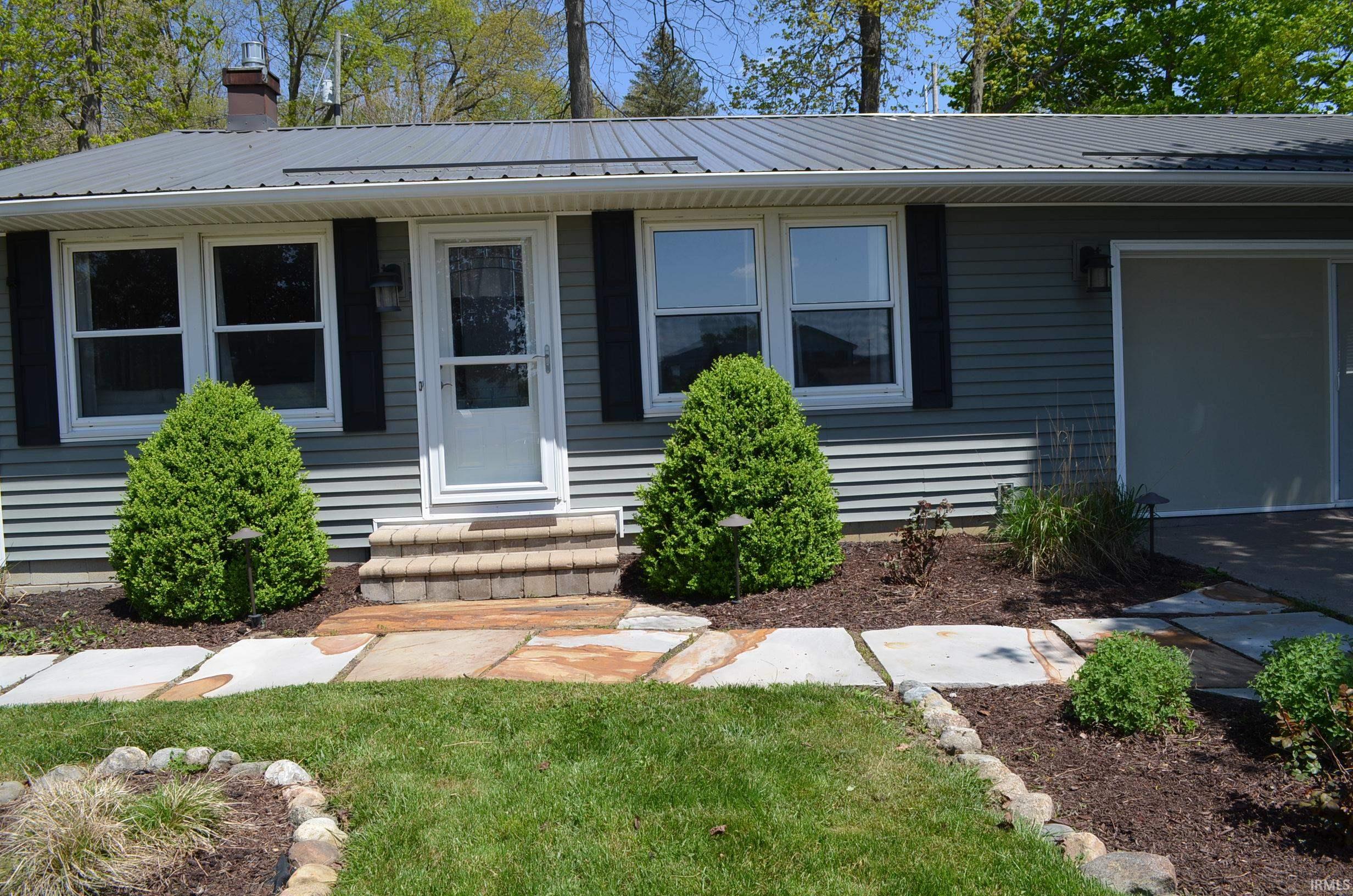 Exterior with blue siding and a metal roof