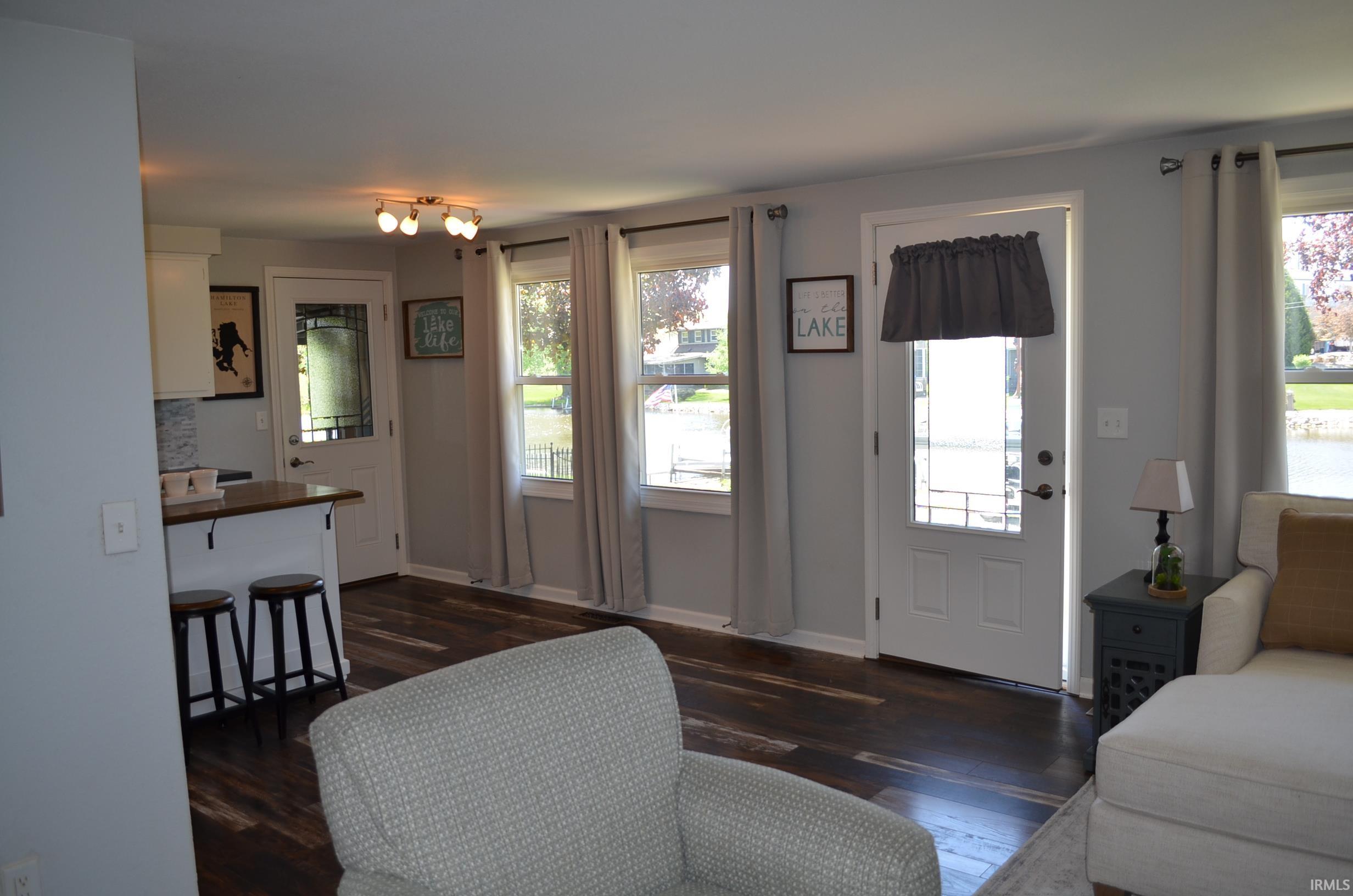 Open concept living space featuring wood-finish flooring, light gray wall paint, and multiple windows