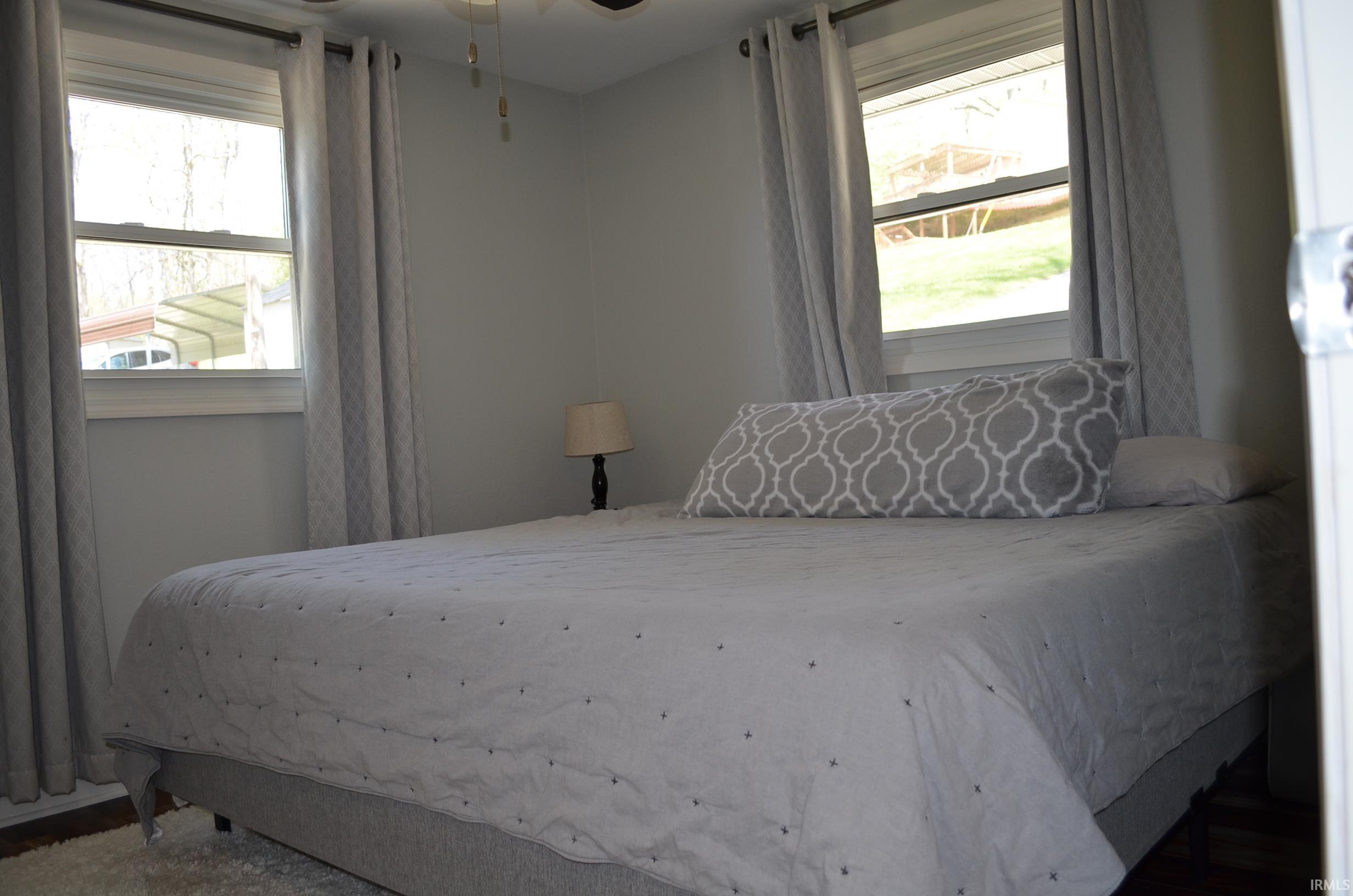 Neutral wall color with two windows featuring custom window treatments