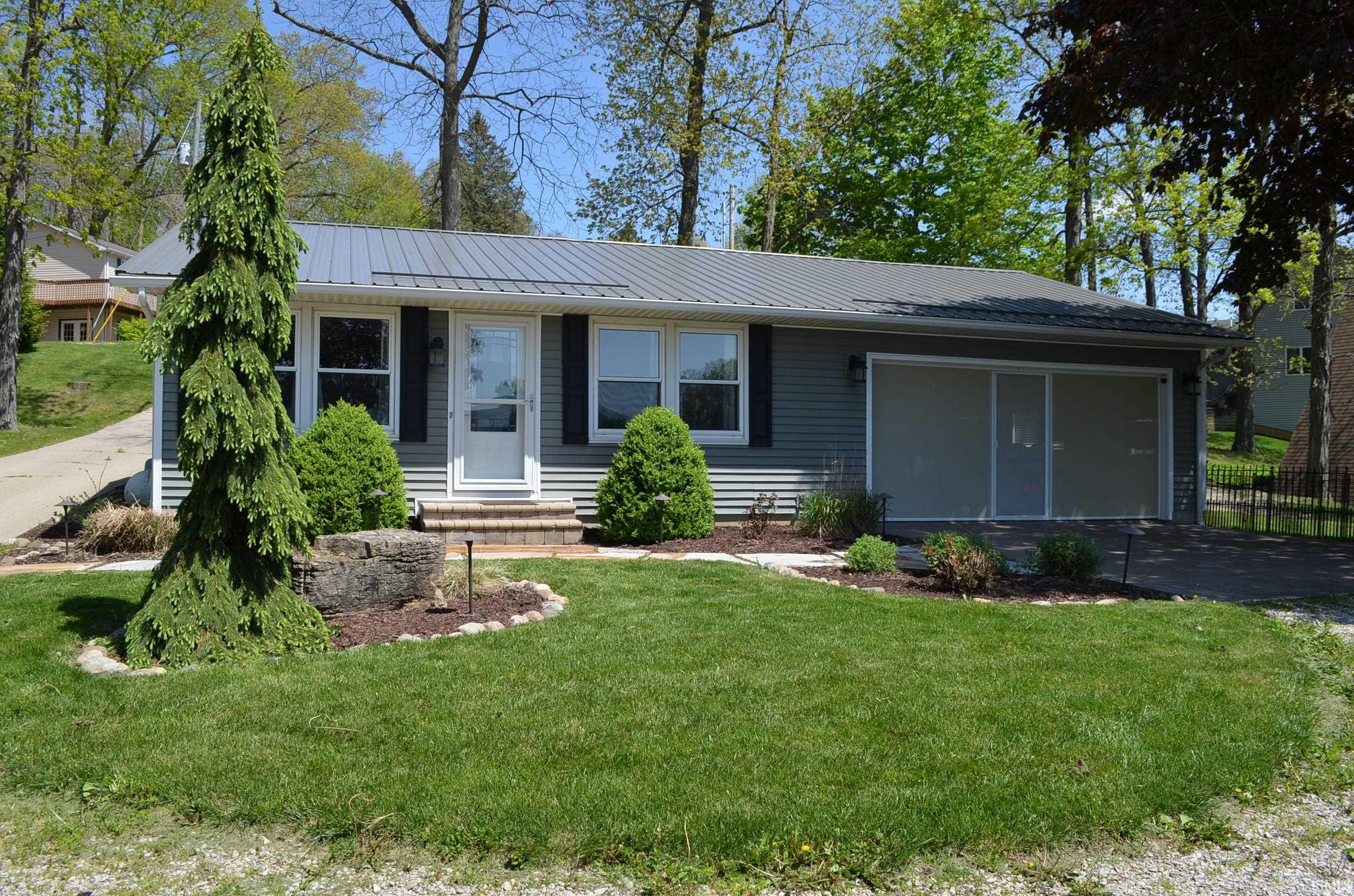 Ranch-style residence featuring a blue metal roof, horizontal siding, and a single-car garage