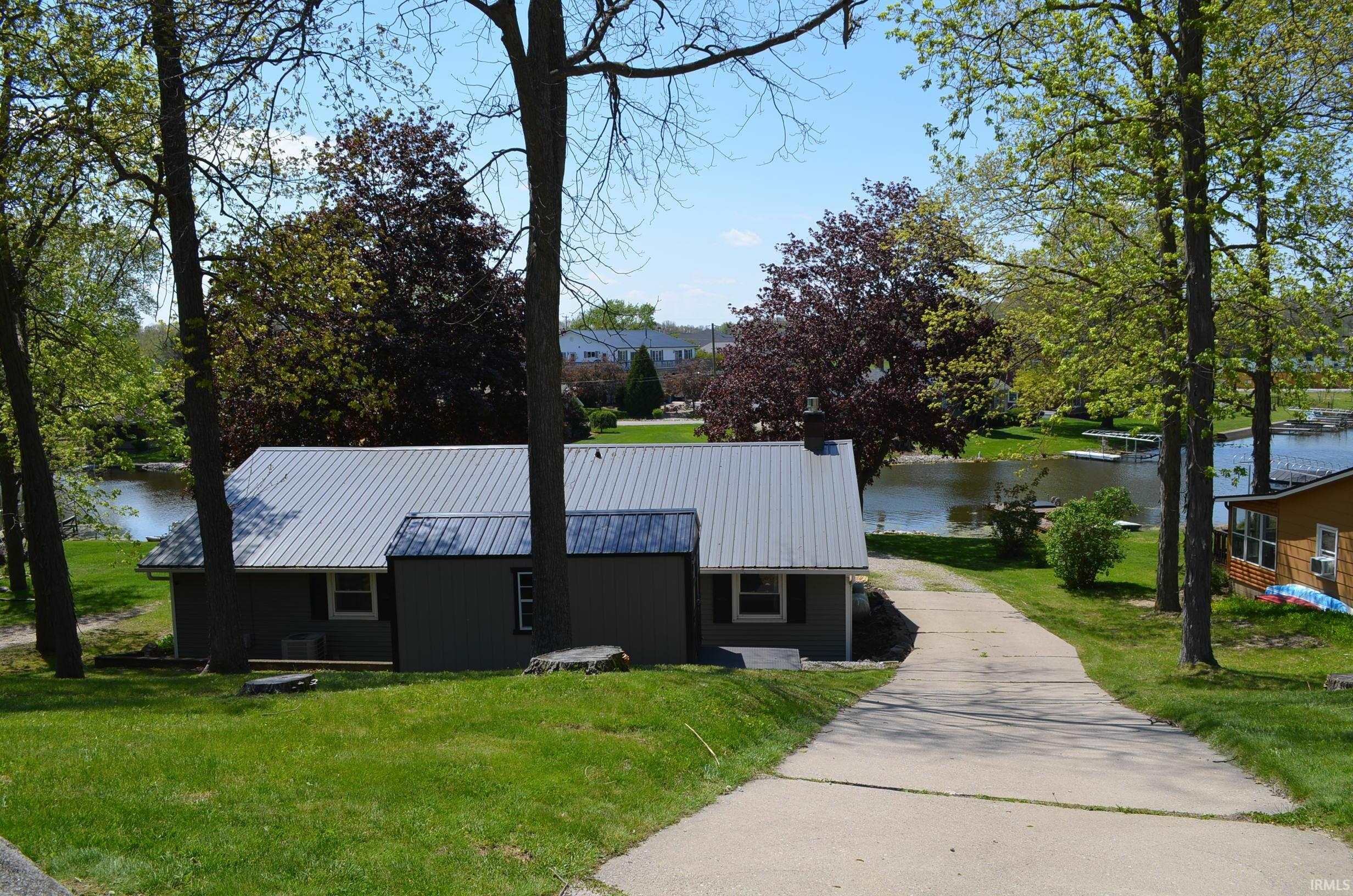 Ranch-style residence featuring a metal roof, blue siding, and white trim