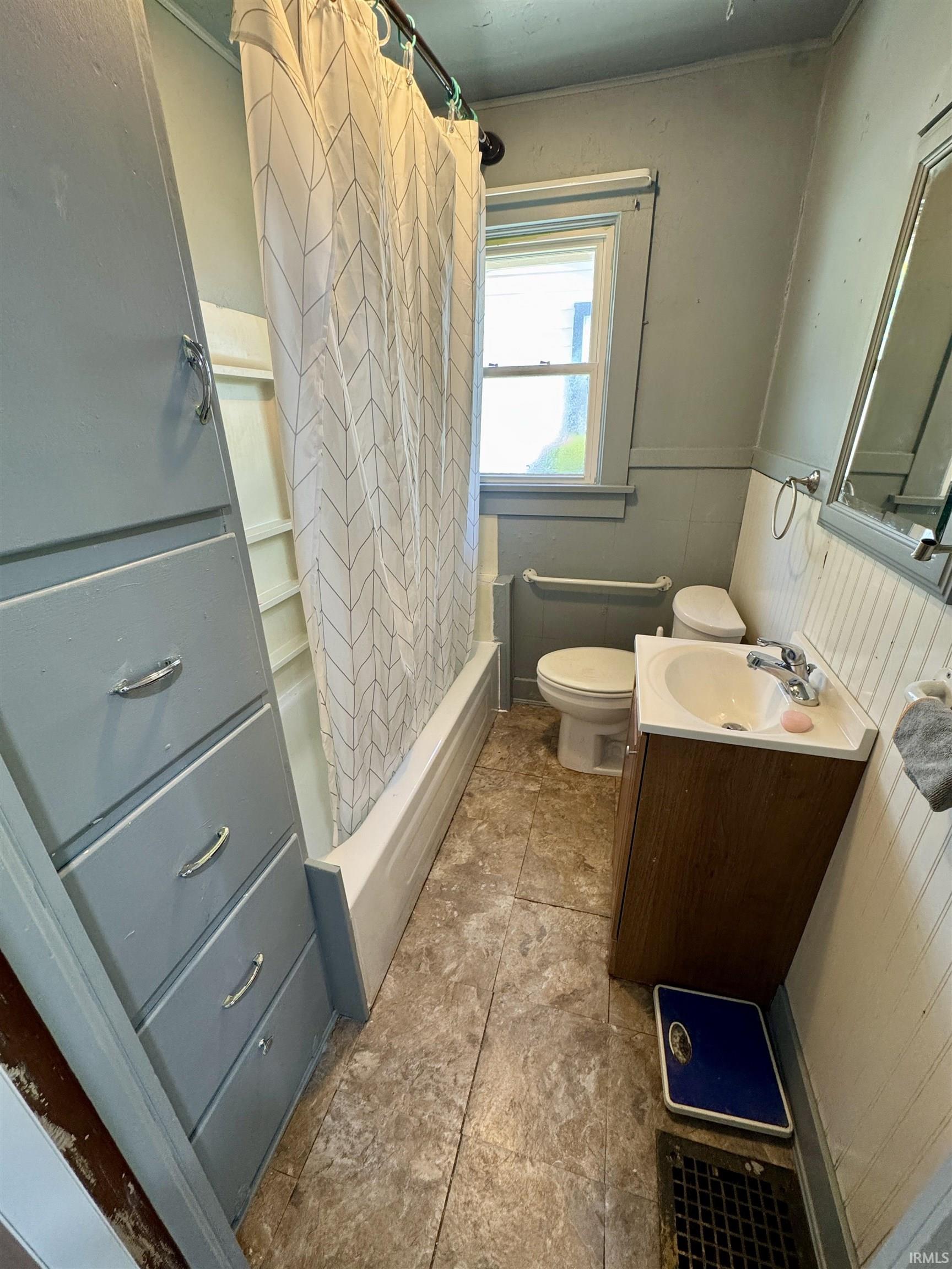 Bathroom featuring a tub with shower, white toilet, and a vanity with a white sink