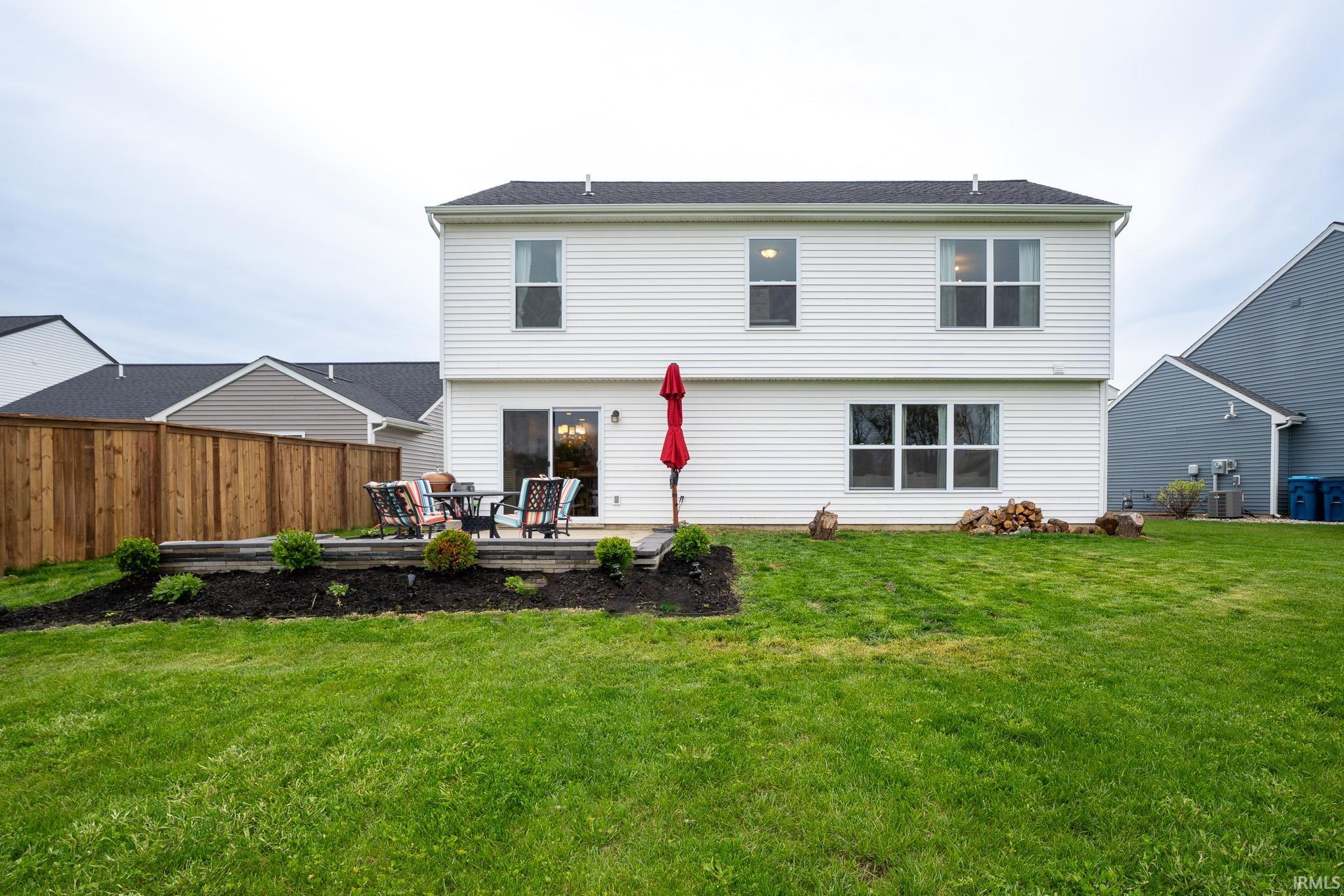 Expansive green lawn with a white vinyl-sided exterior