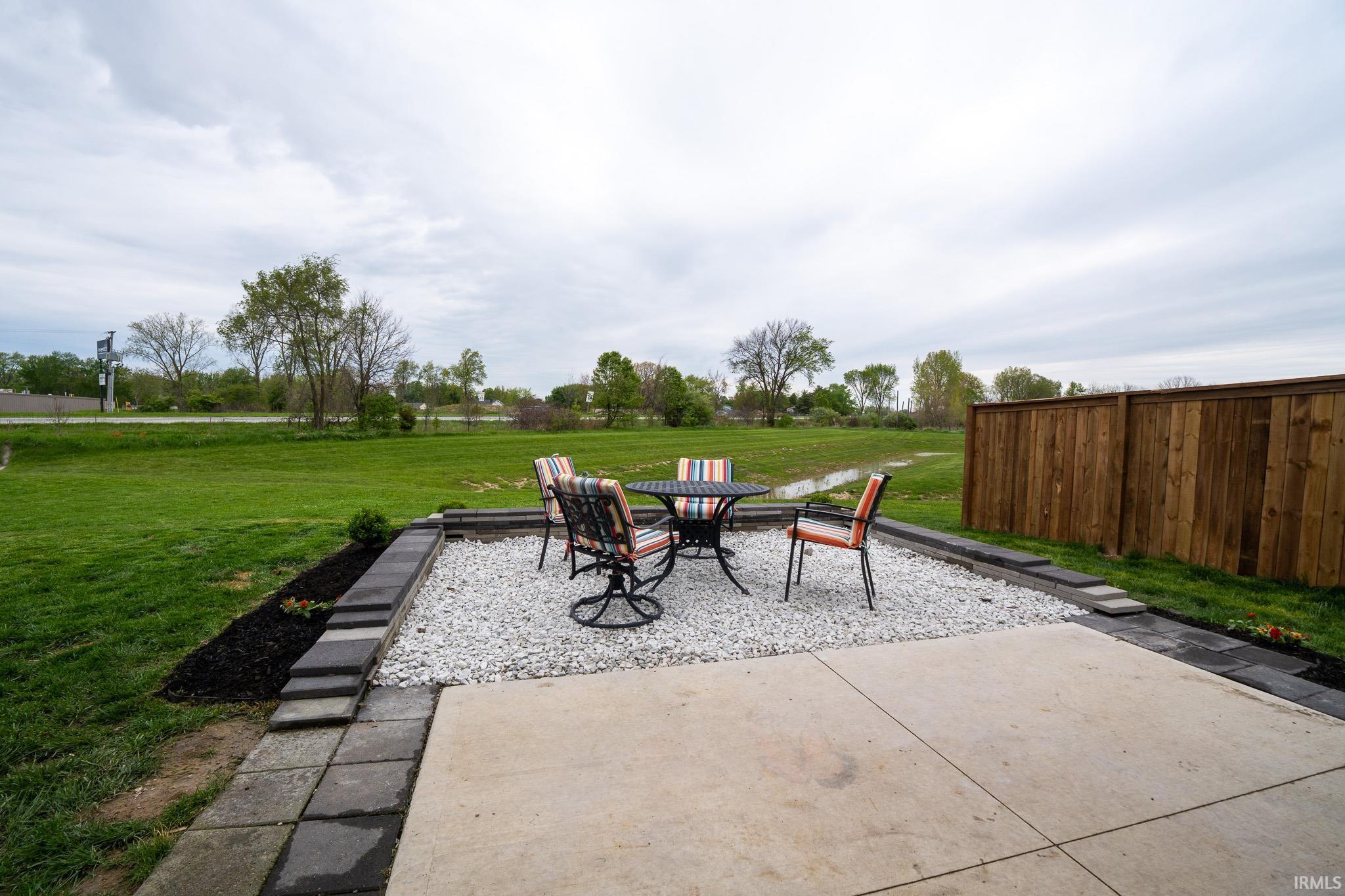 Outdoor concrete patio extending to a white gravel seating area