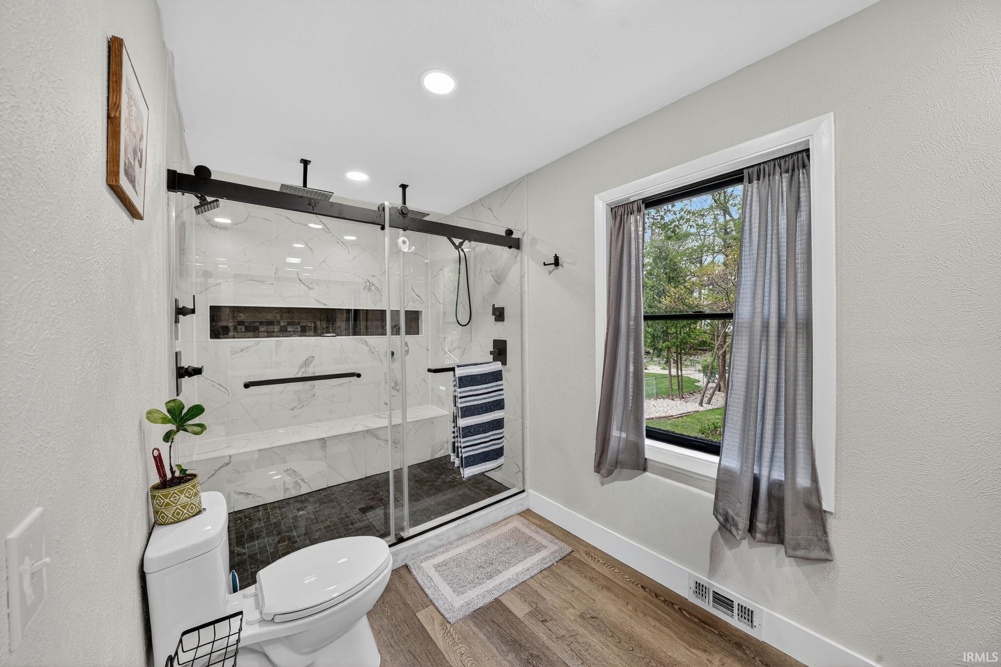 Contemporary bathroom featuring a spacious walk-in shower with black-framed glass doors