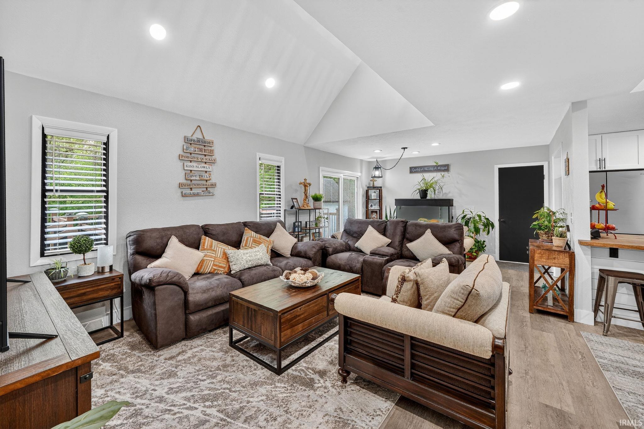 Open-concept living area featuring a vaulted ceiling with recessed lighting