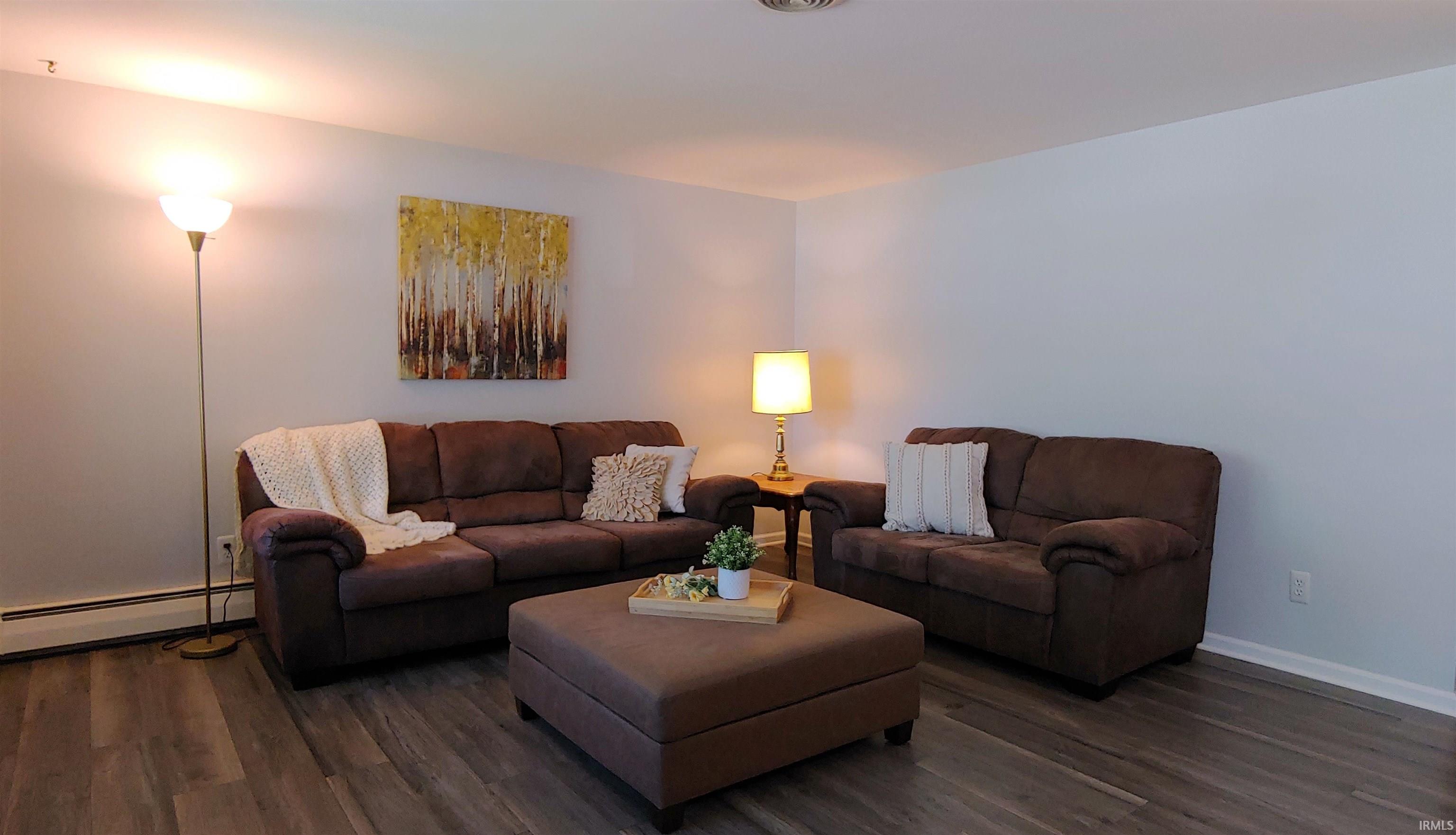 Spacious living area featuring vinyl plank flooring, white baseboards and trim.