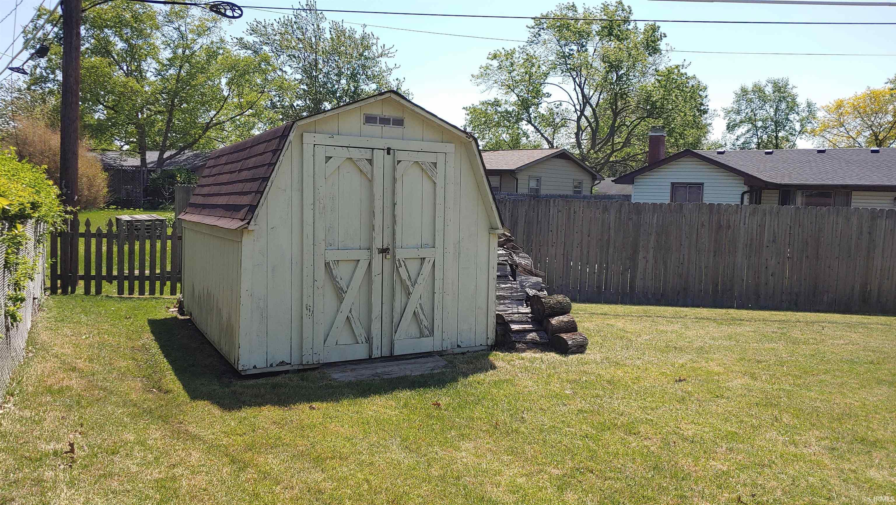 Gable-roof shed with double entry doors and a shingle roof.  There is a attic platform that offers more storage.