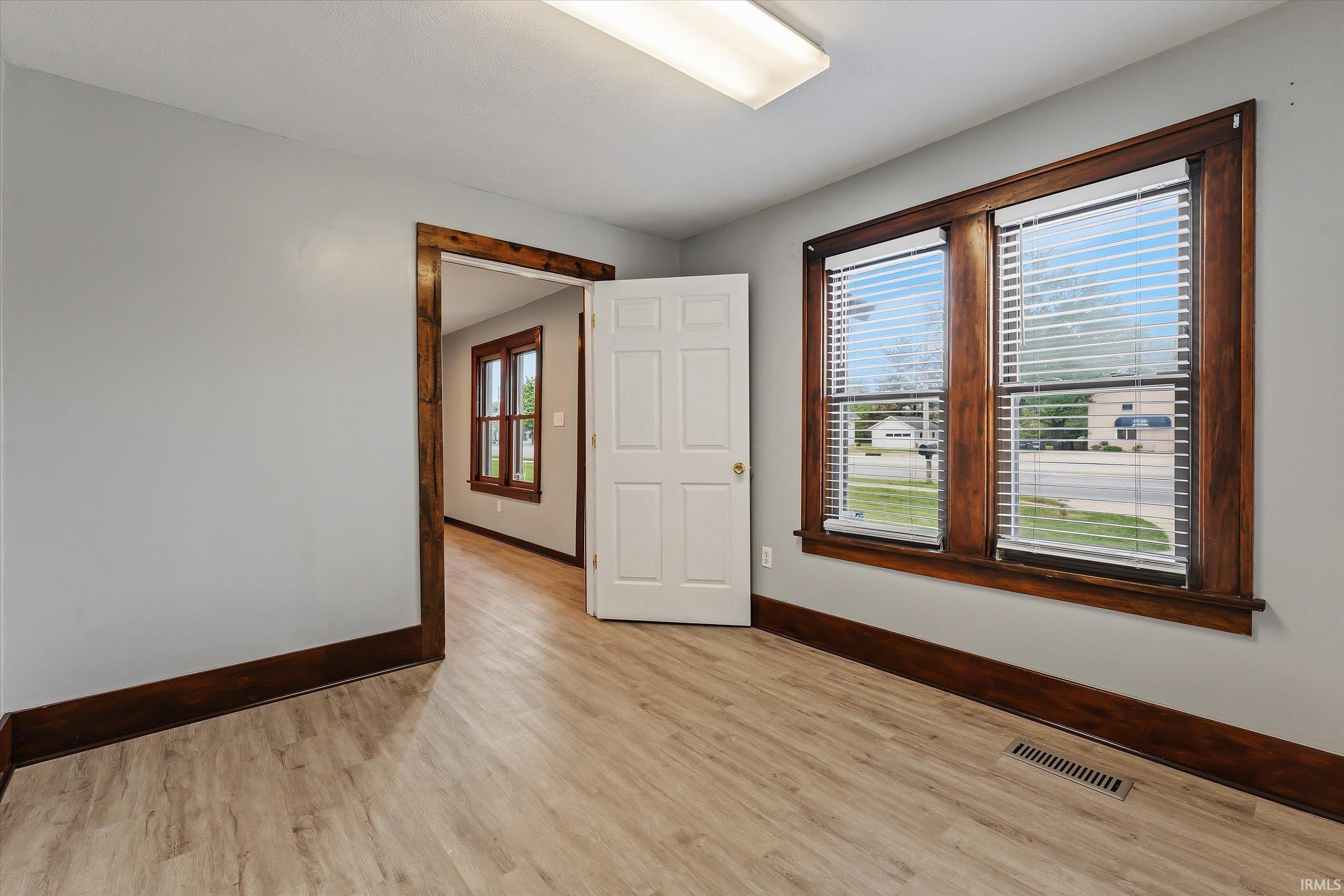 Room with light wood-finish flooring and light gray walls