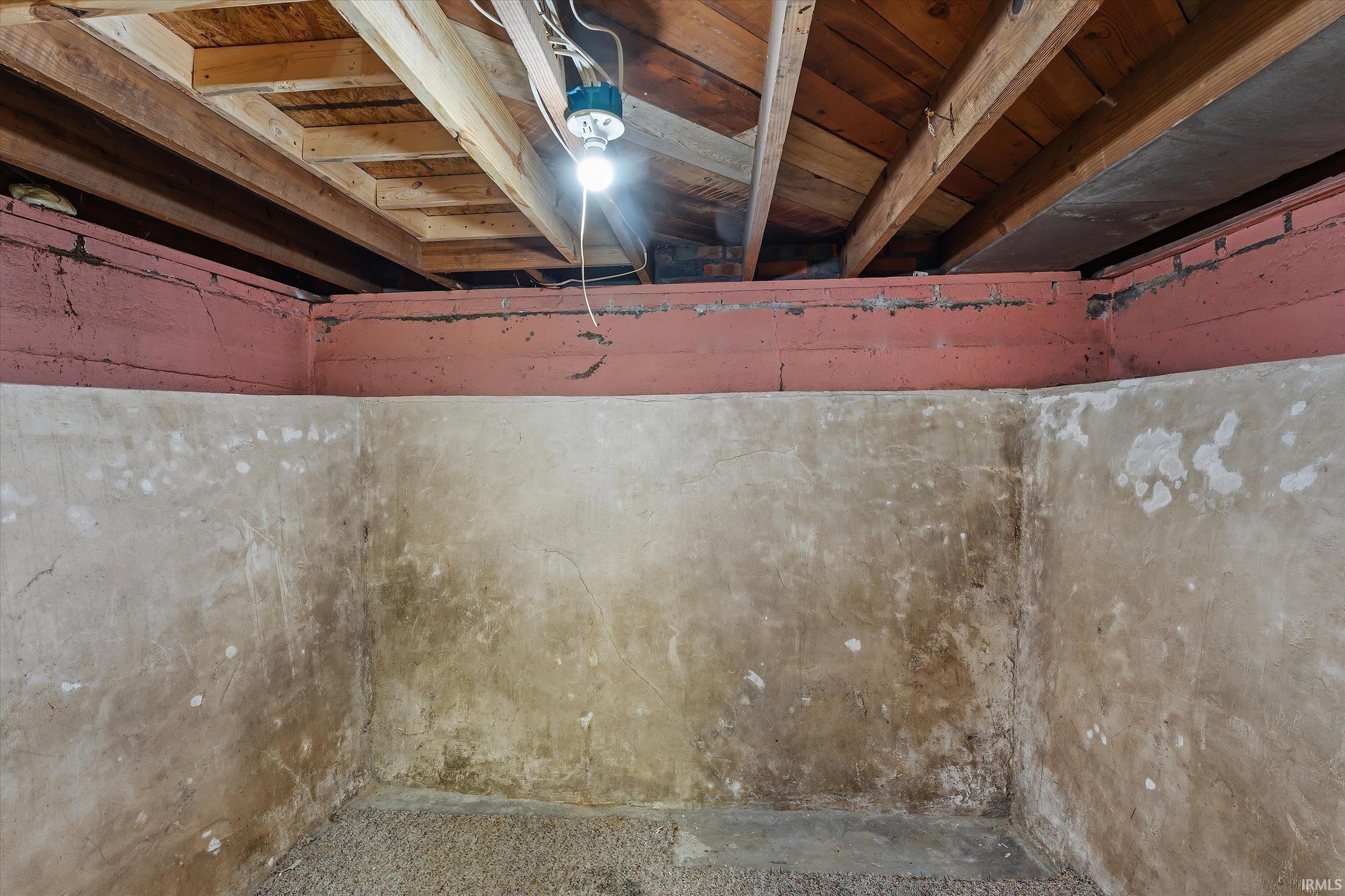 Exposed wooden ceiling joists and subflooring with visible electrical wiring