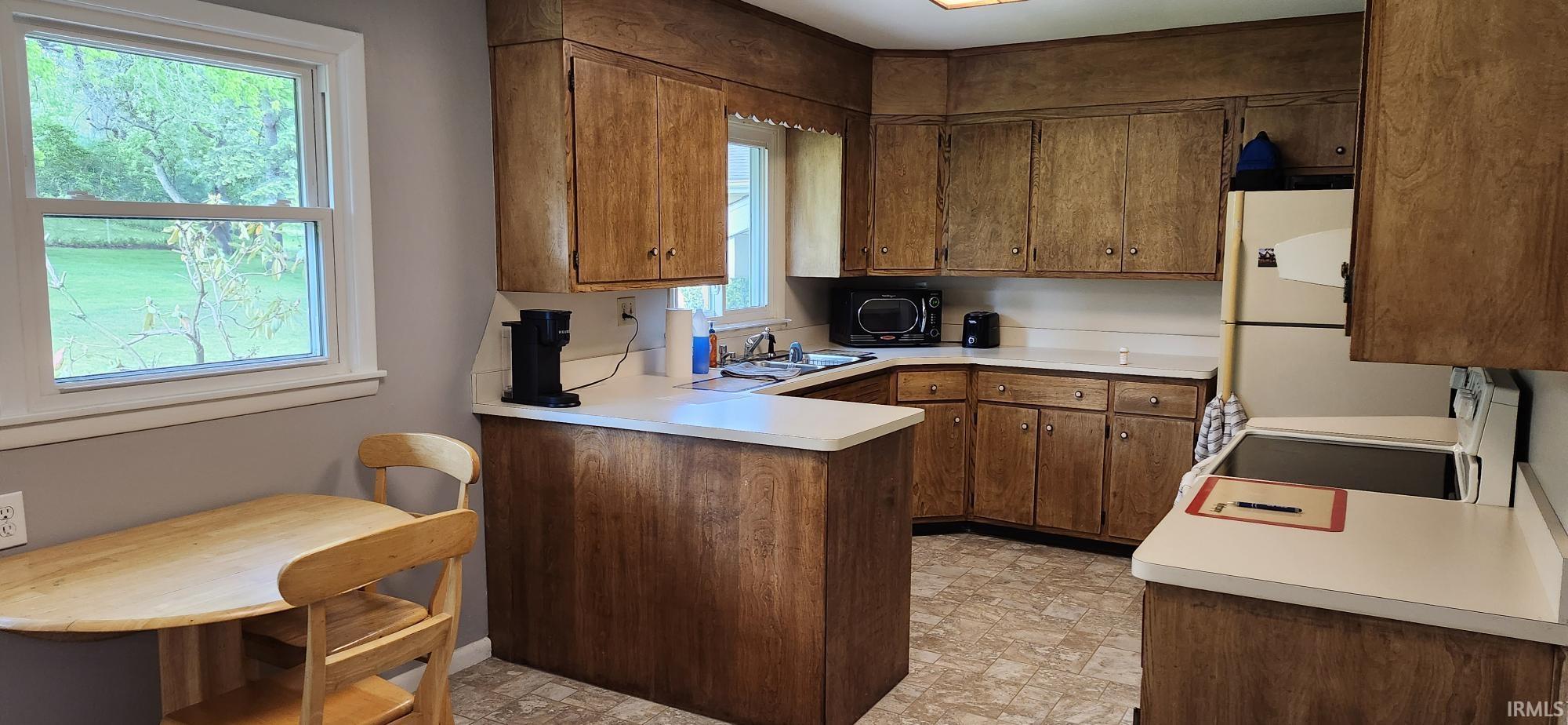 Kitchen featuring wood-finish cabinetry, white countertops, and vinyl flooring