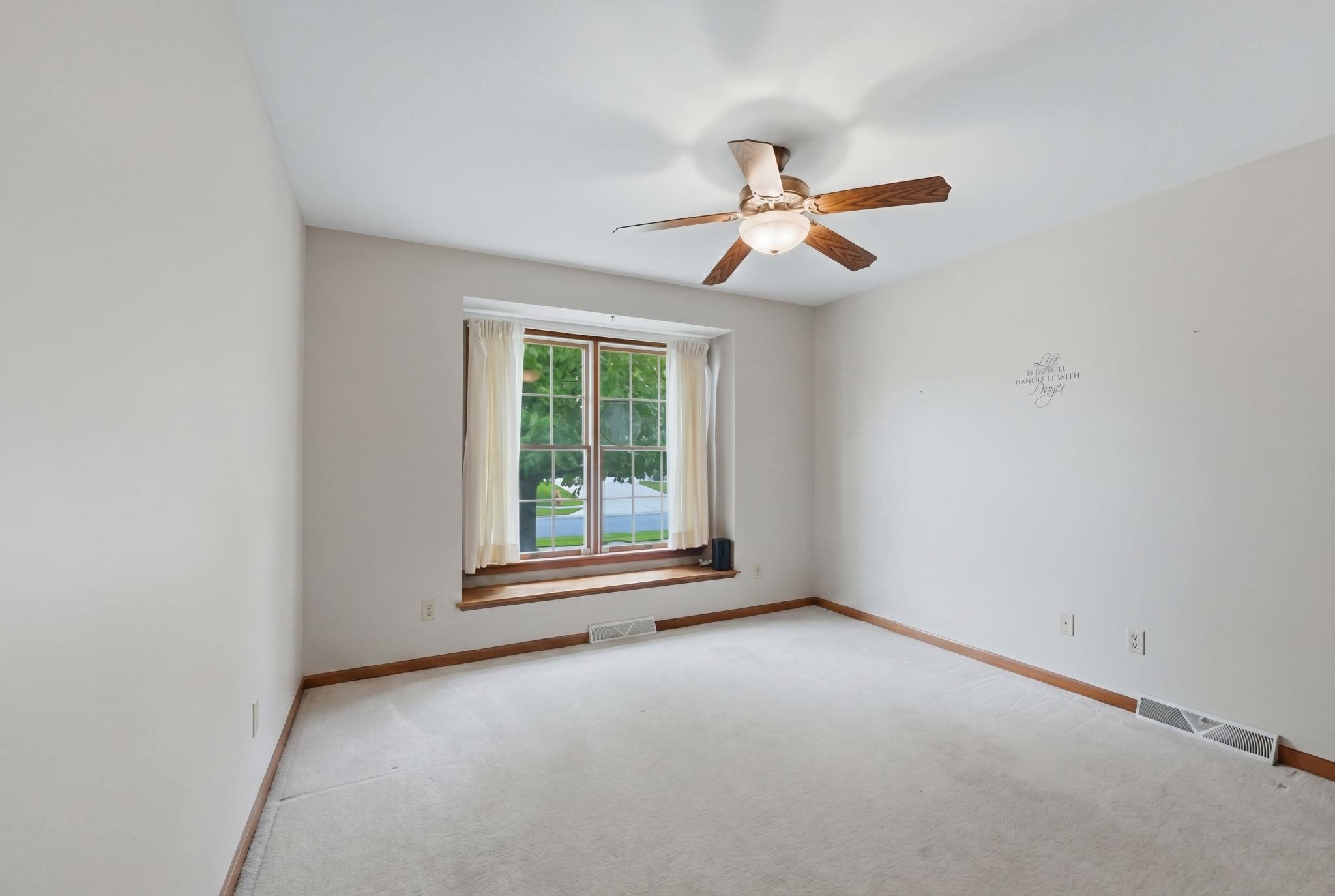 Carpeted interior with a large window featuring a wood sill and trim