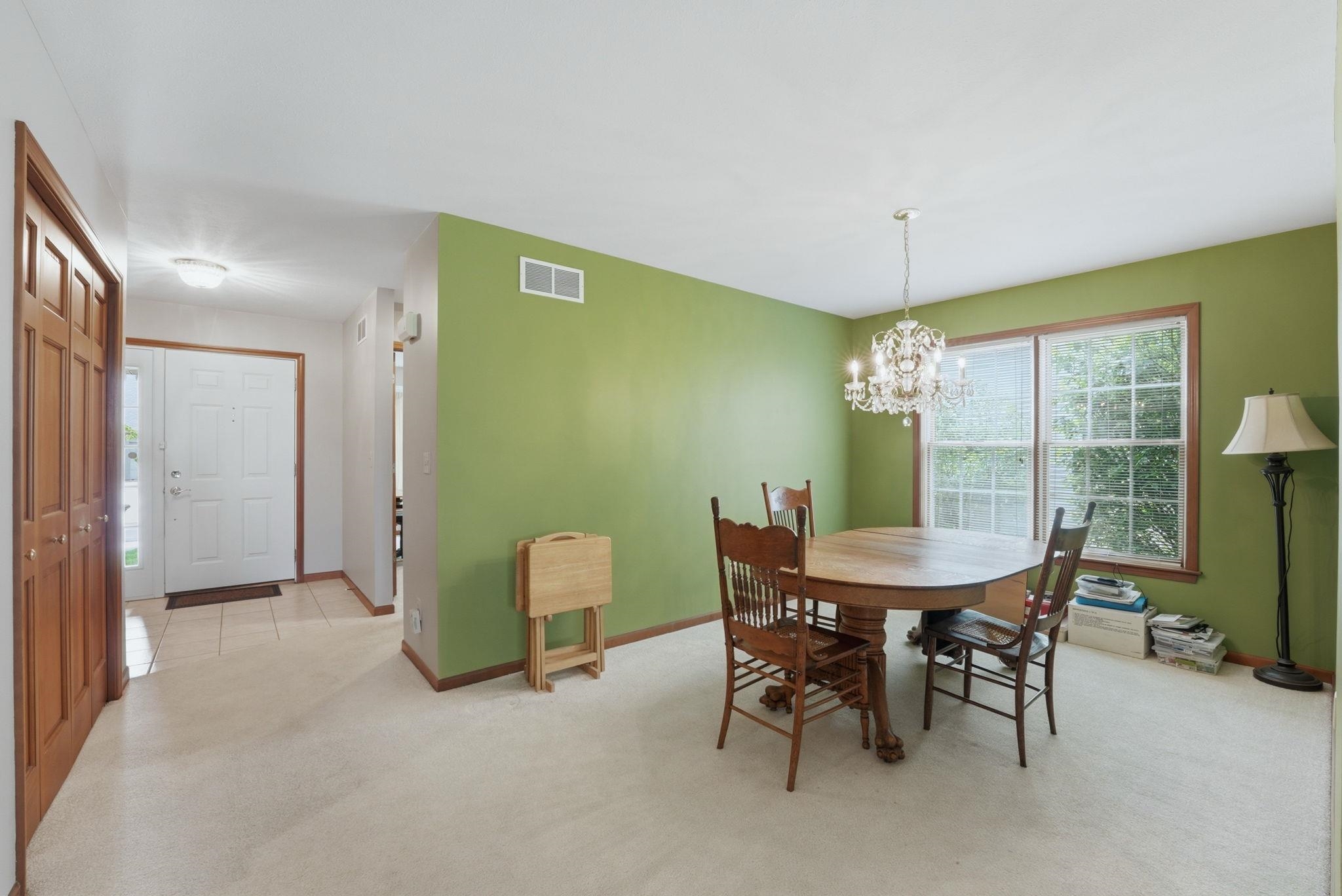 Dining area featuring a chandelier, large window, and light green walls