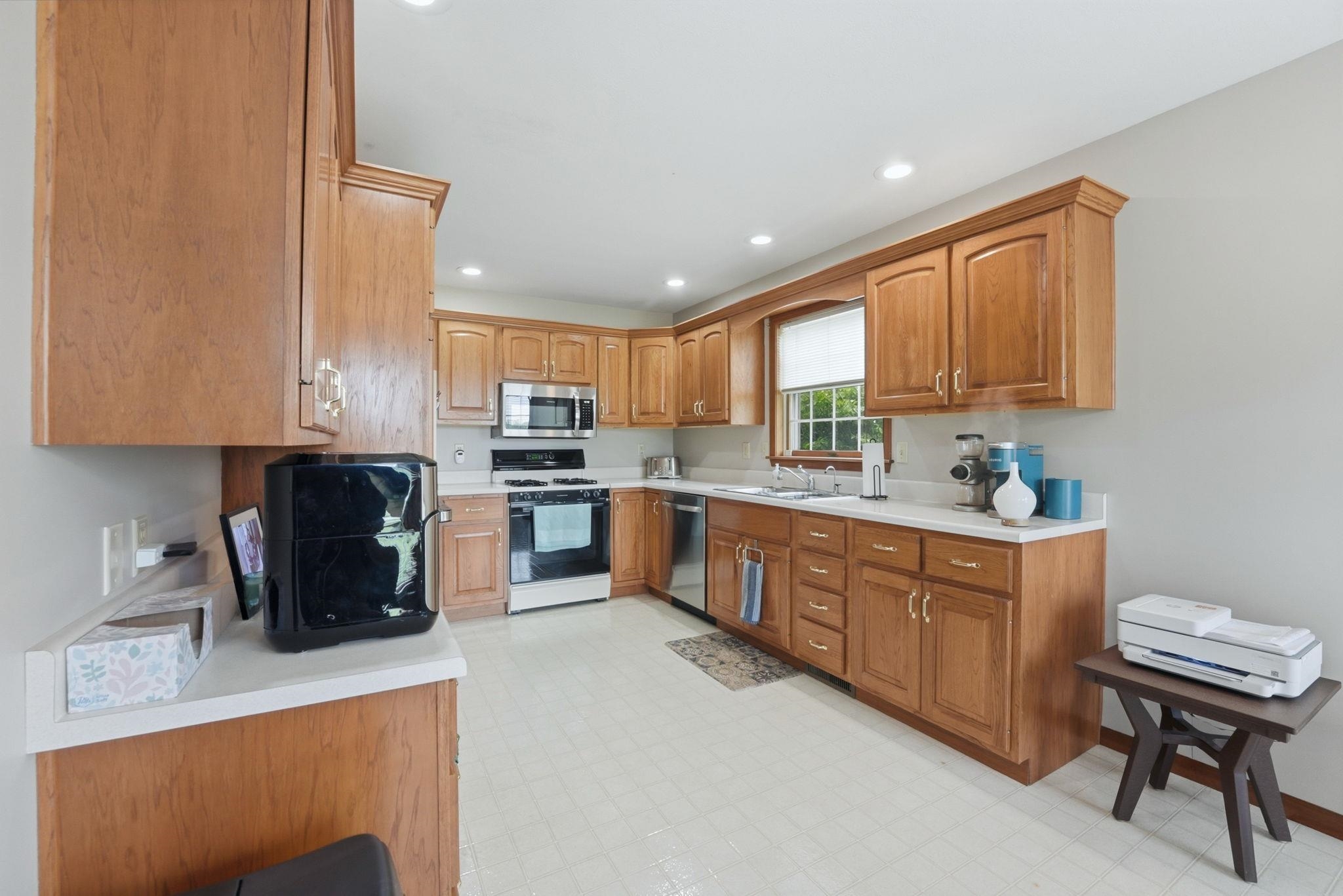 Kitchen featuring wood cabinetry, white countertops, stainless steel appliances, and recessed lighting