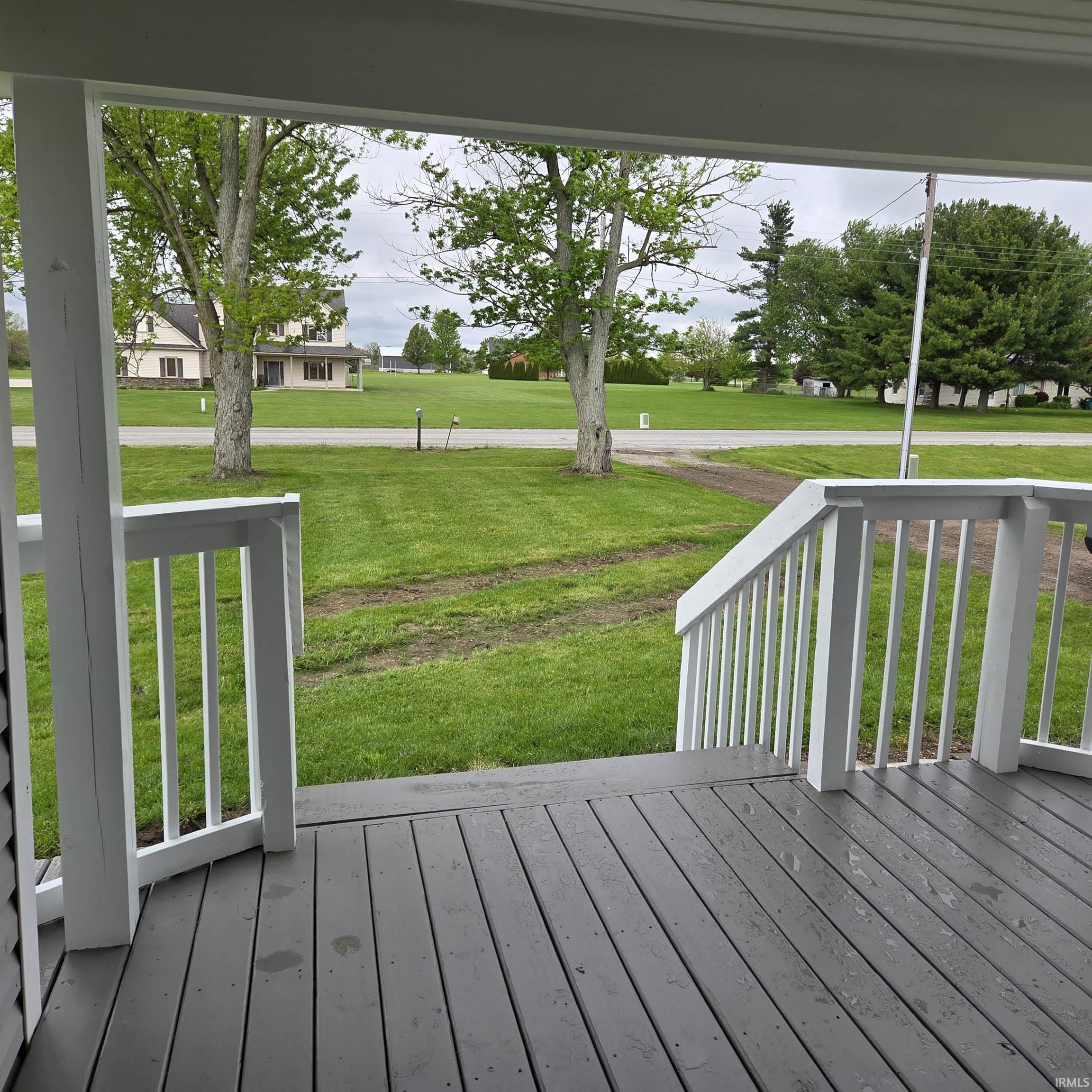 Covered porch with gray wood-finish decking and white painted railings