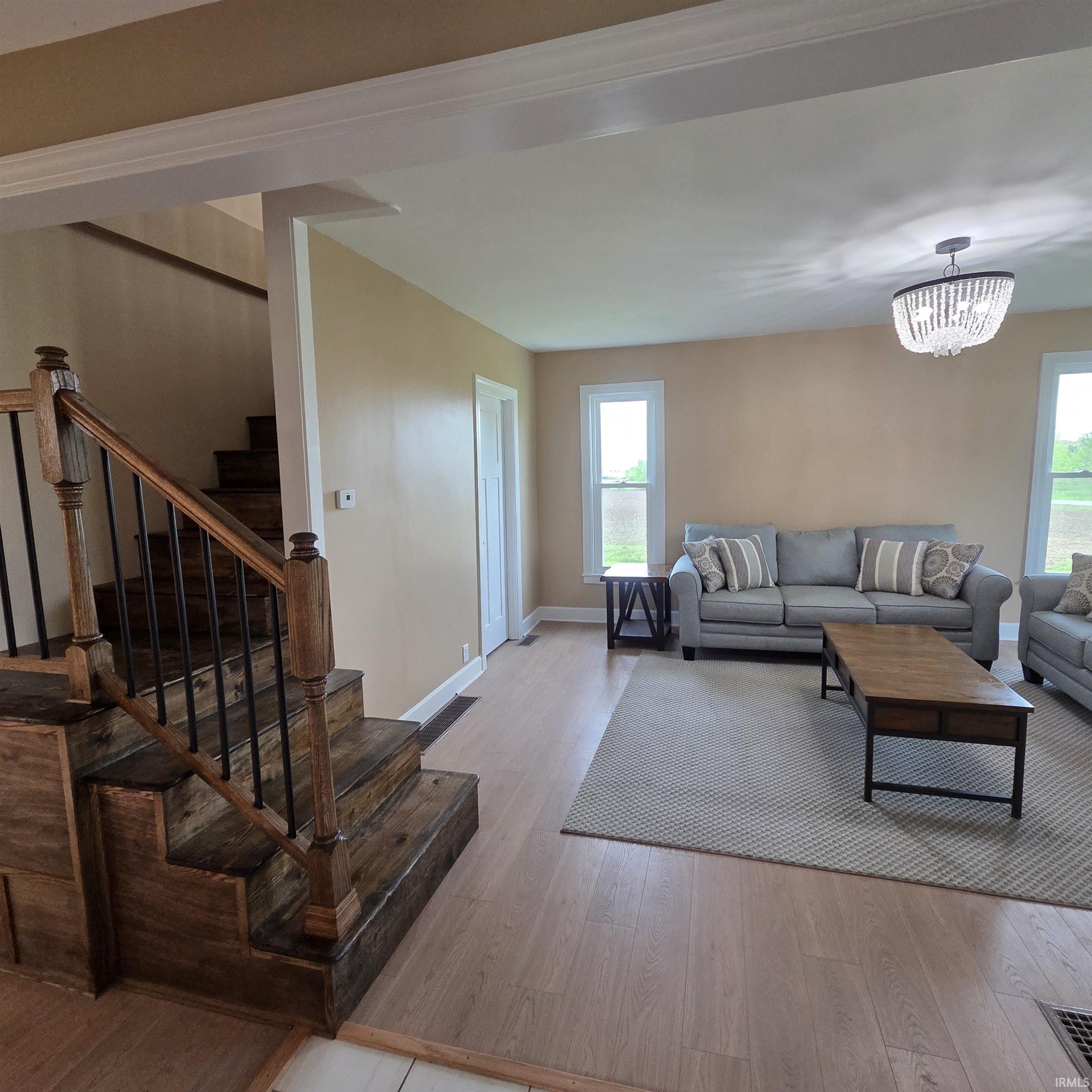 Open-concept living space with light-tone wood-finish flooring