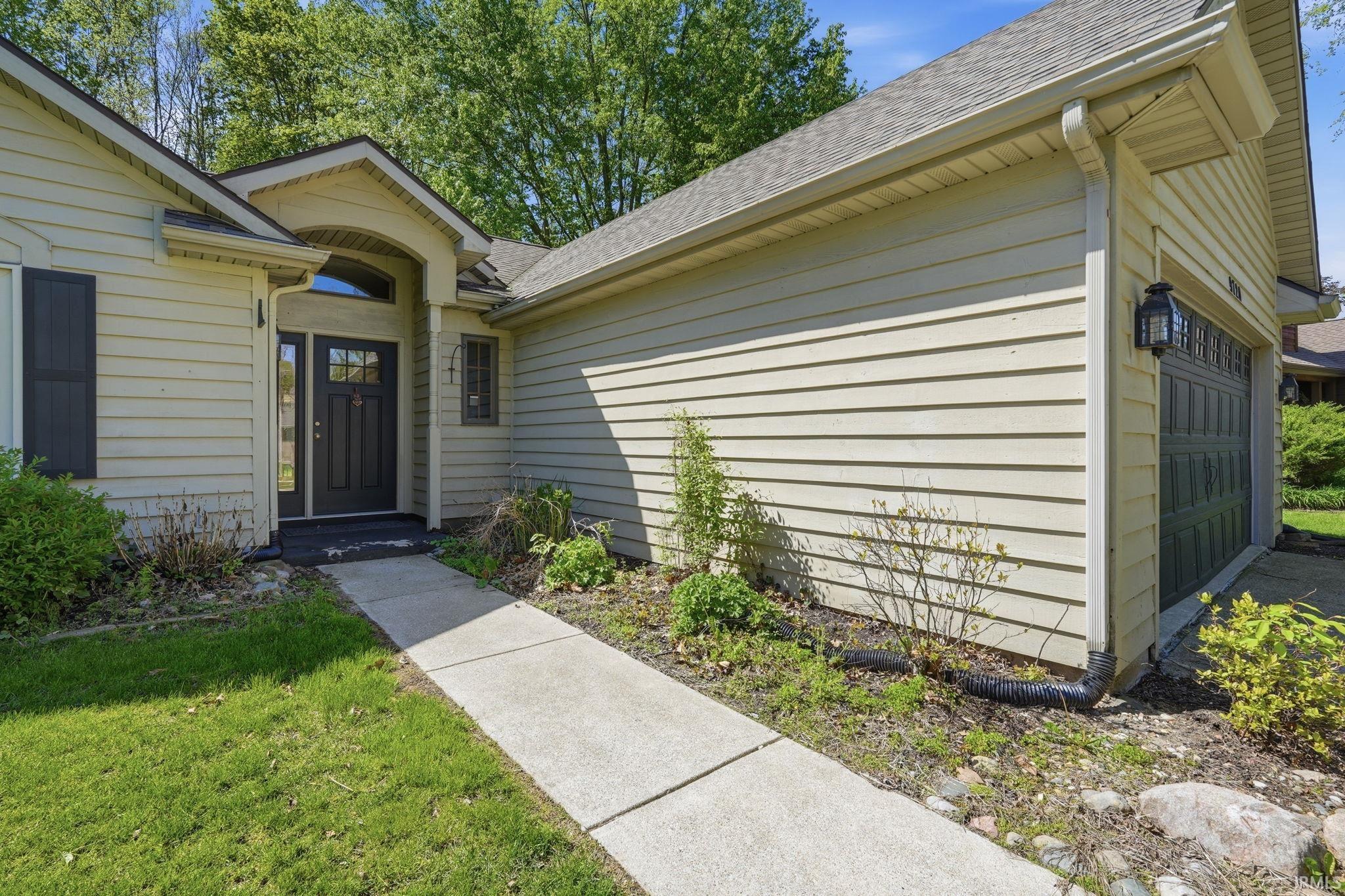 Exterior featuring horizontal siding and a dark paneled front door with sidelights