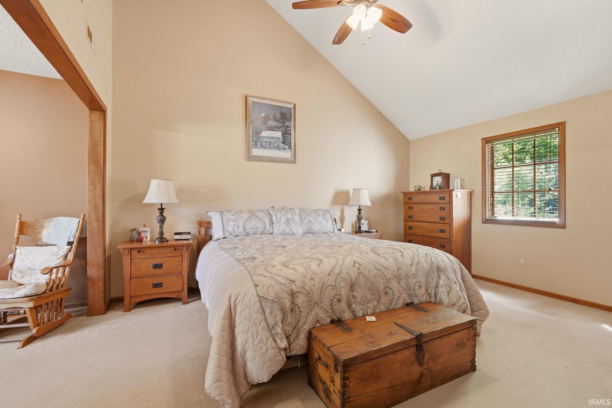 Vaulted ceiling with a wood-finish ceiling fan and integrated lighting
