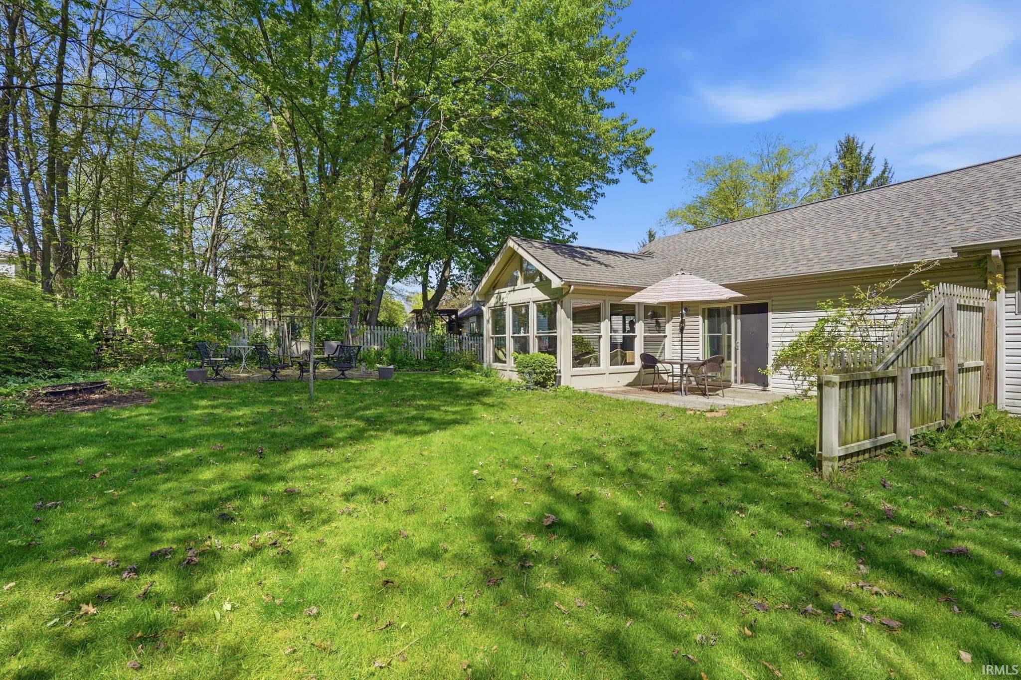 Expansive green lawn with mature trees bordering the property
