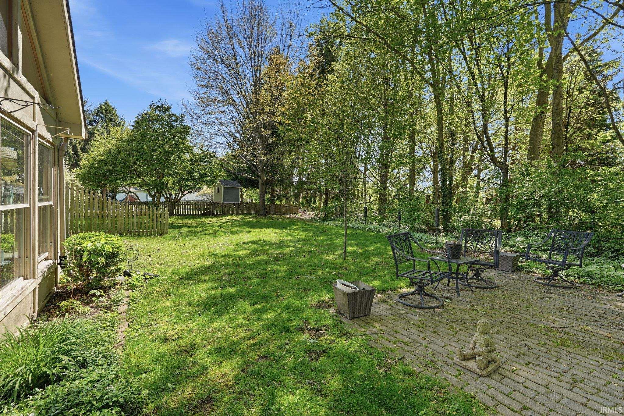Expansive green lawn with a brick paver patio