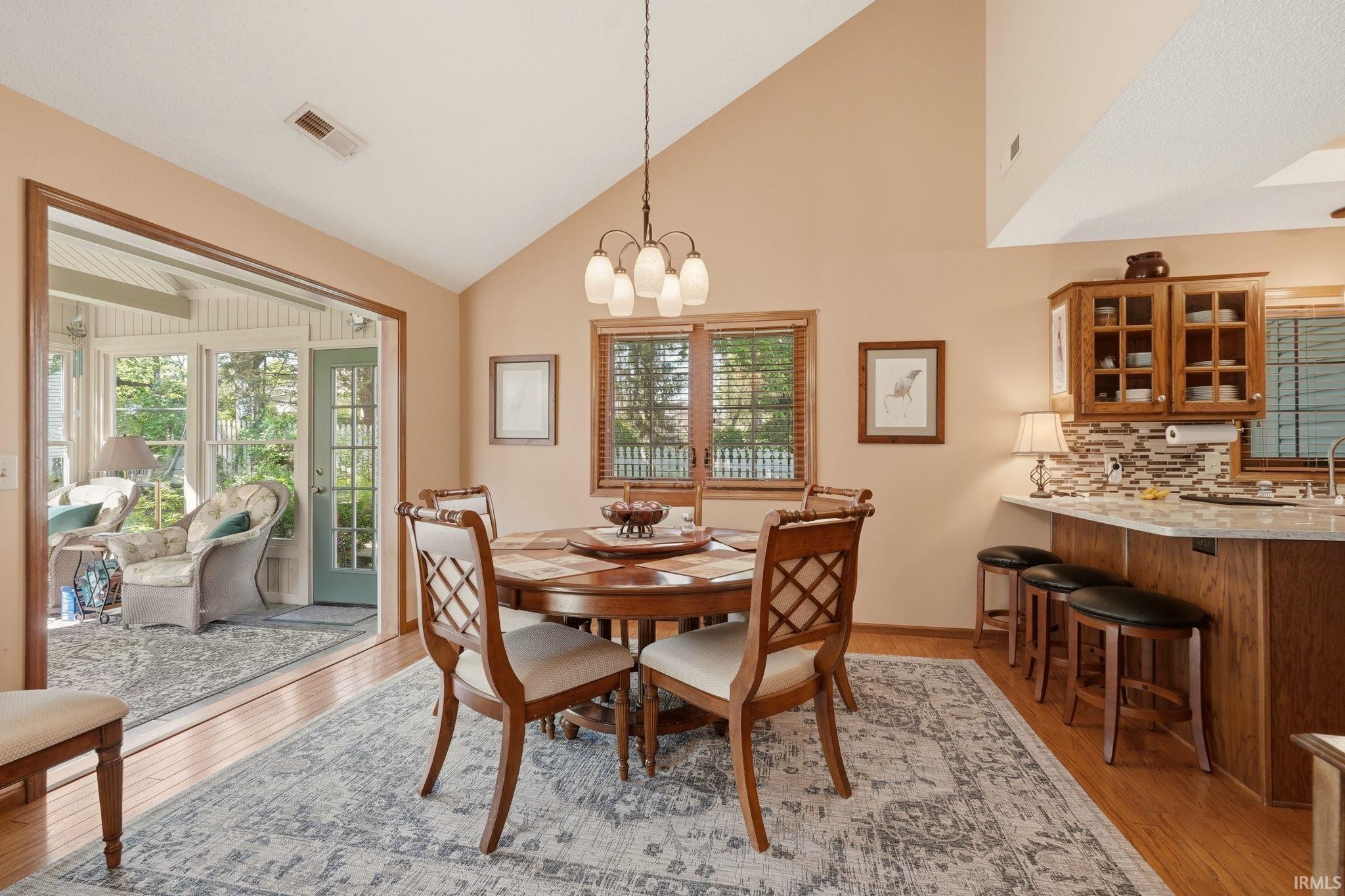 Dining area featuring wood-finish flooring and a vaulted ceiling