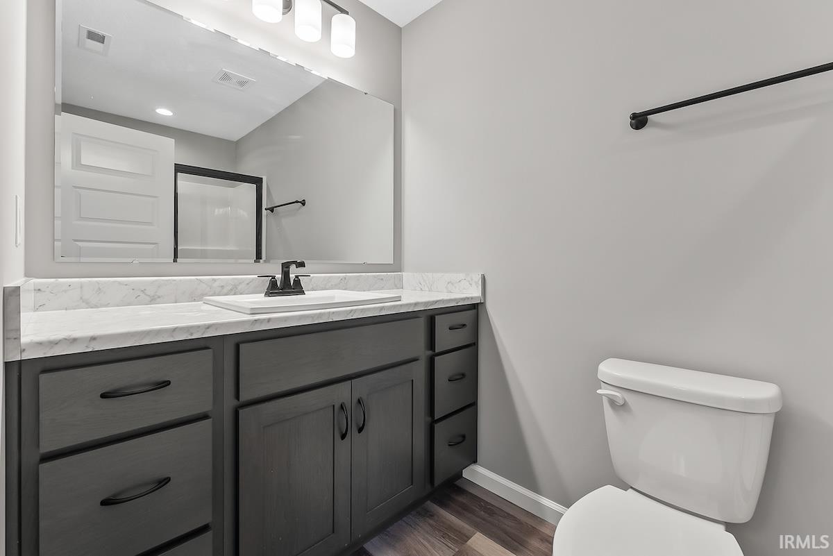 Bathroom vanity with a white countertop and integrated sink, matte black faucet, and dark gray cabinetry with black hardware
