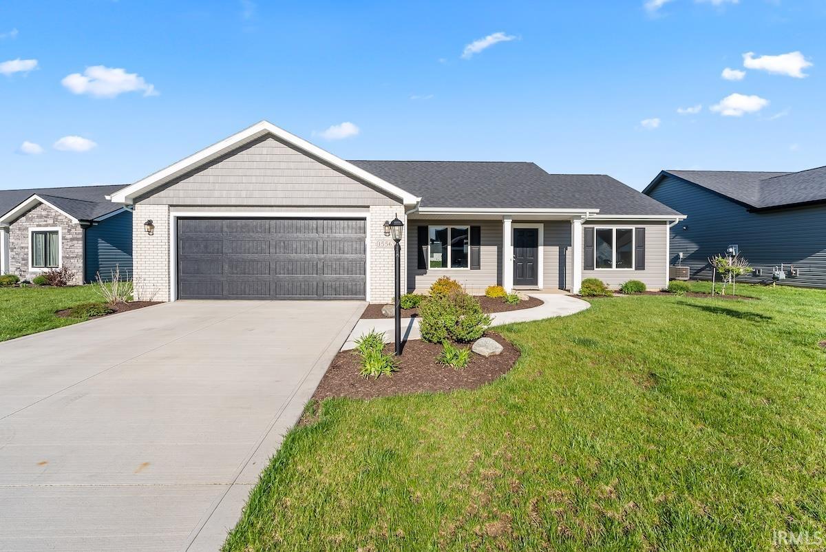 Contemporary ranch-style residence featuring a gray exterior, dark shingle roof, and a two-car garage