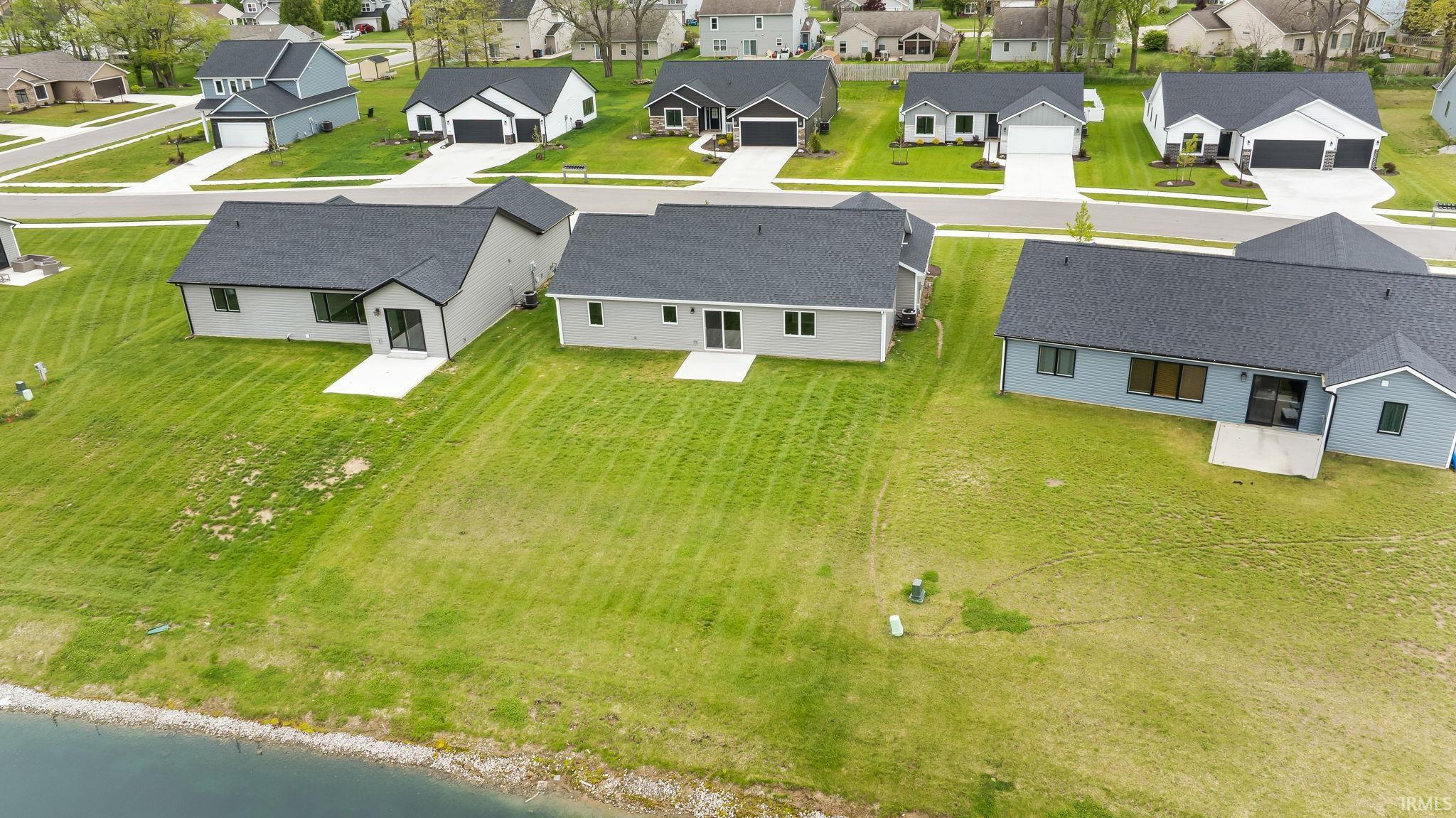 Rear exterior featuring a manicured lawn sloping towards a body of water