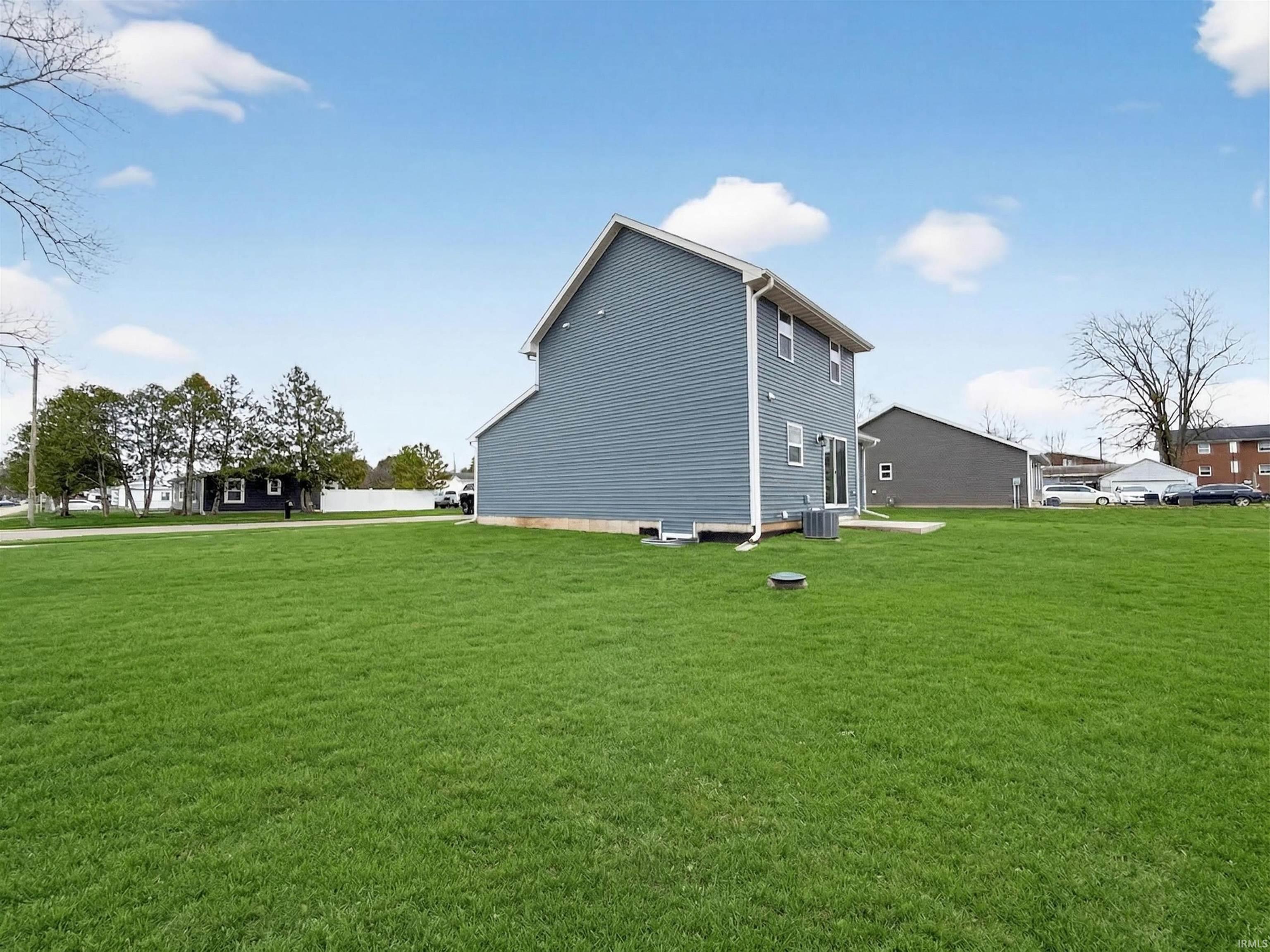 Expansive green lawn surrounds the property