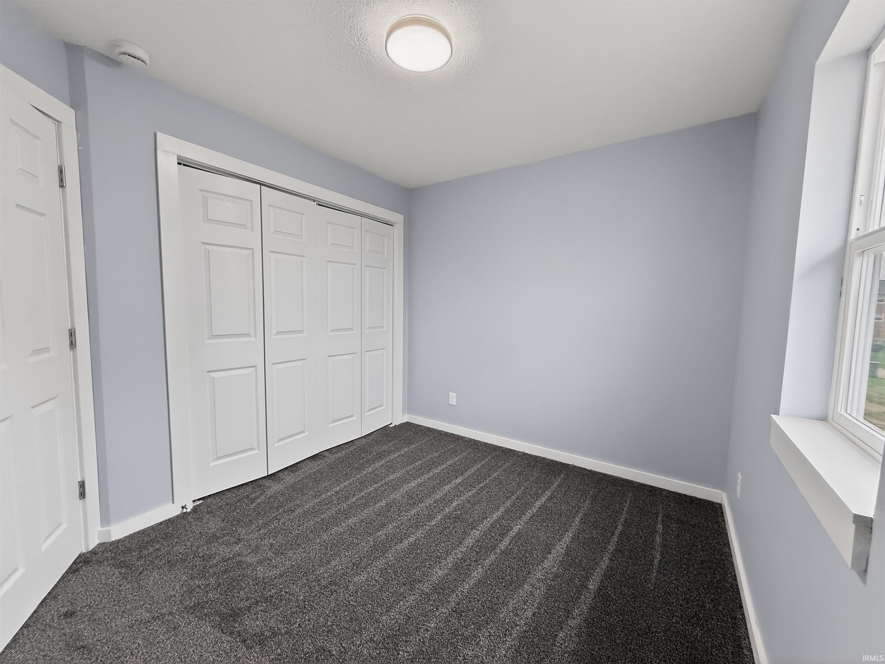 Interior room featuring light blue walls and dark gray patterned carpet