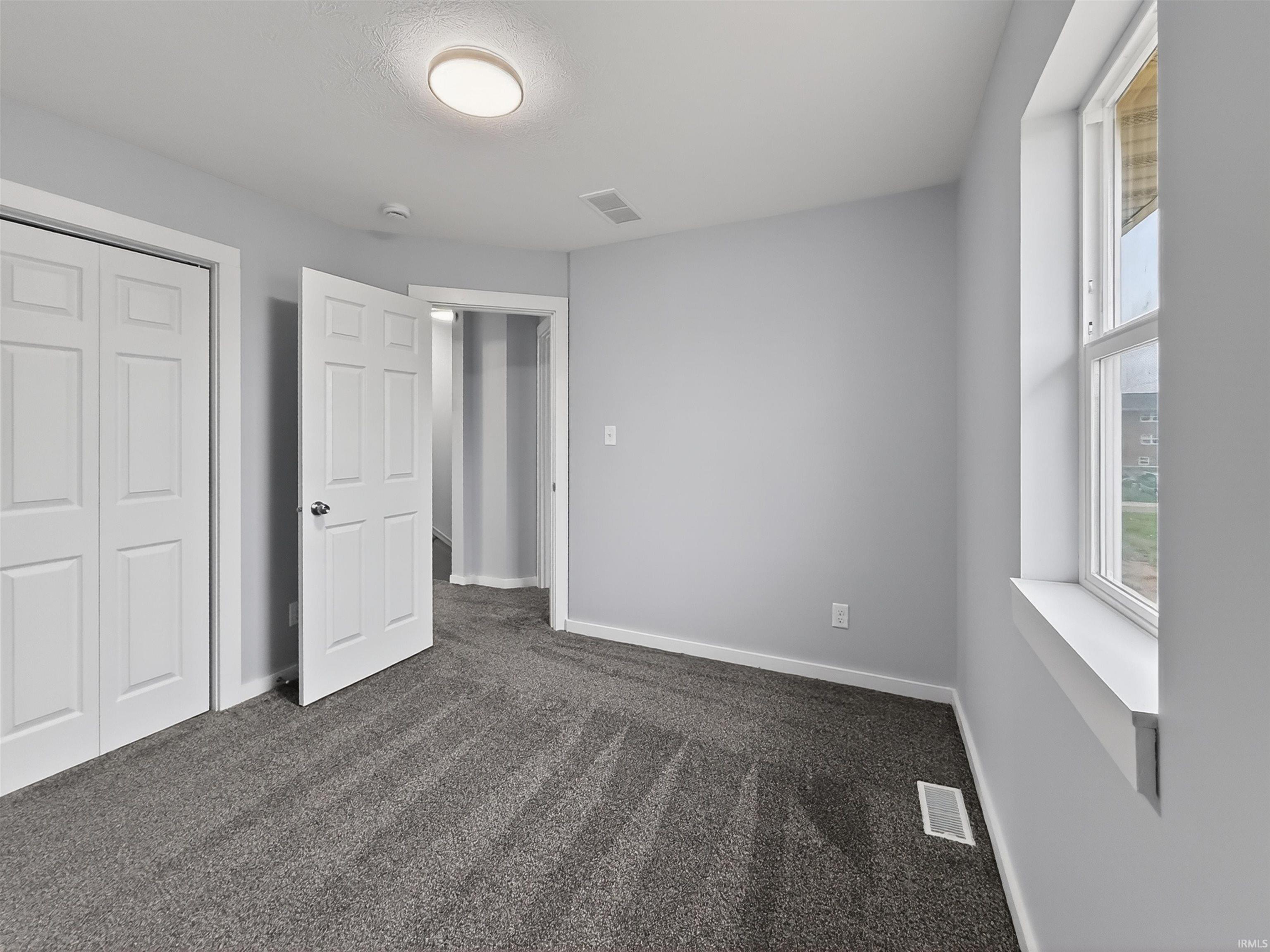Room featuring gray carpeting, light gray wall paint, and white trim