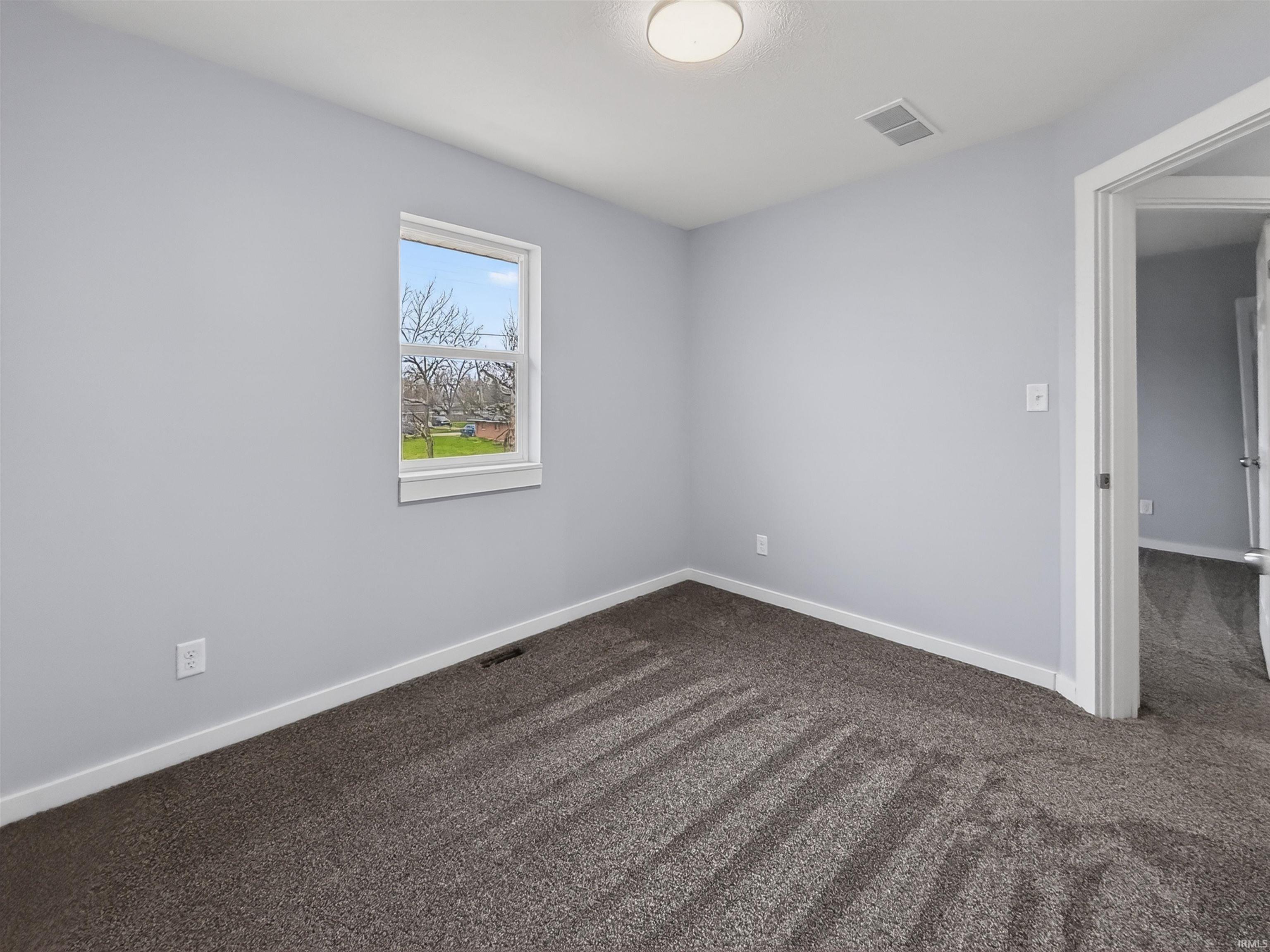 Neutral gray walls complement the charcoal-toned carpet flooring