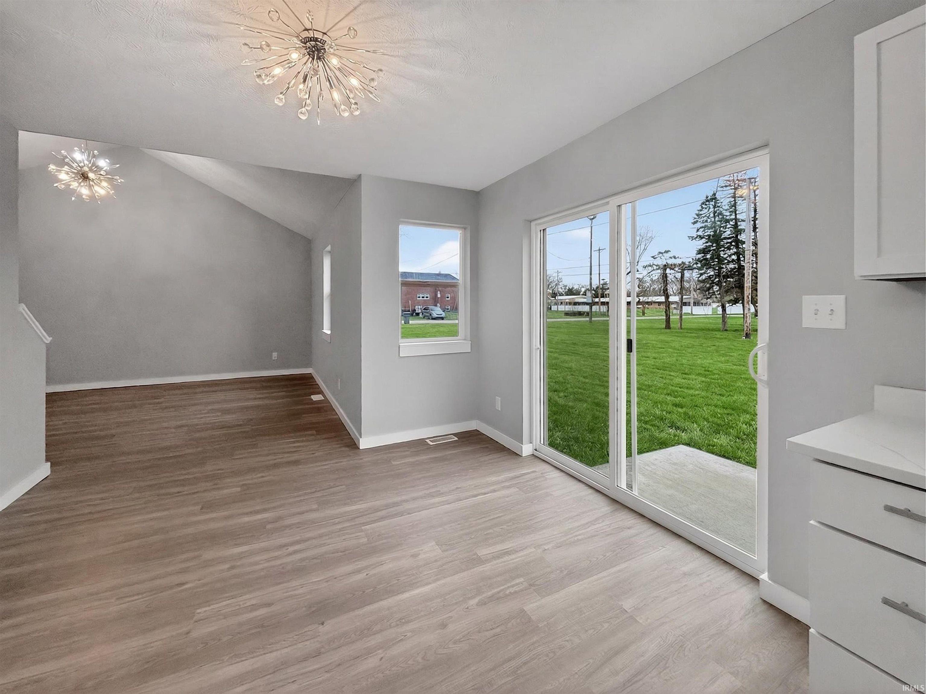 Bright interior with light wood-finish flooring and a vaulted ceiling