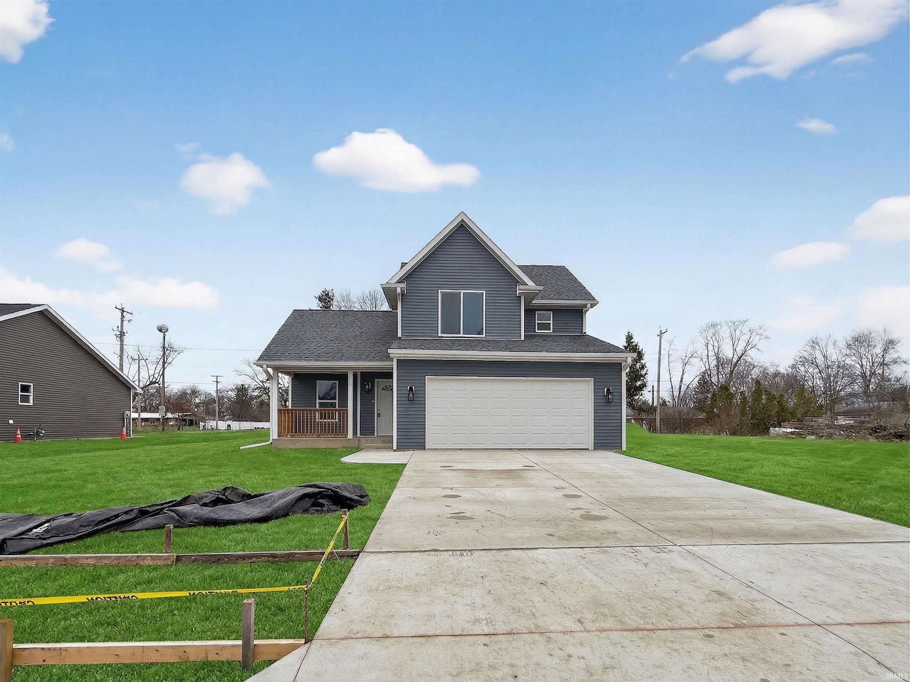 Two-story residence featuring blue siding and a prominent attached two-car garage