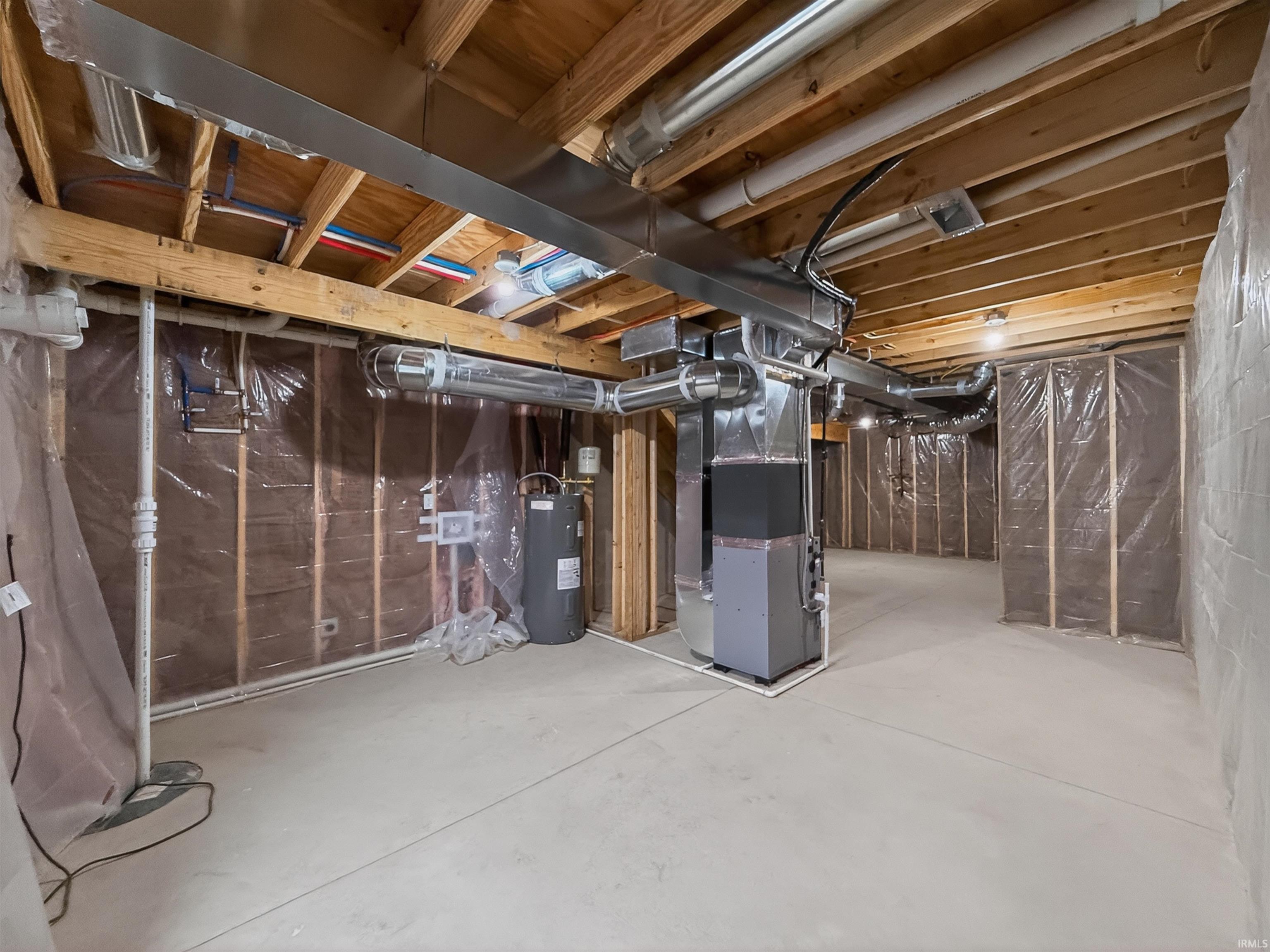 Unfinished basement space featuring exposed joists, concrete flooring, and utilities including a water heater and HVAC system