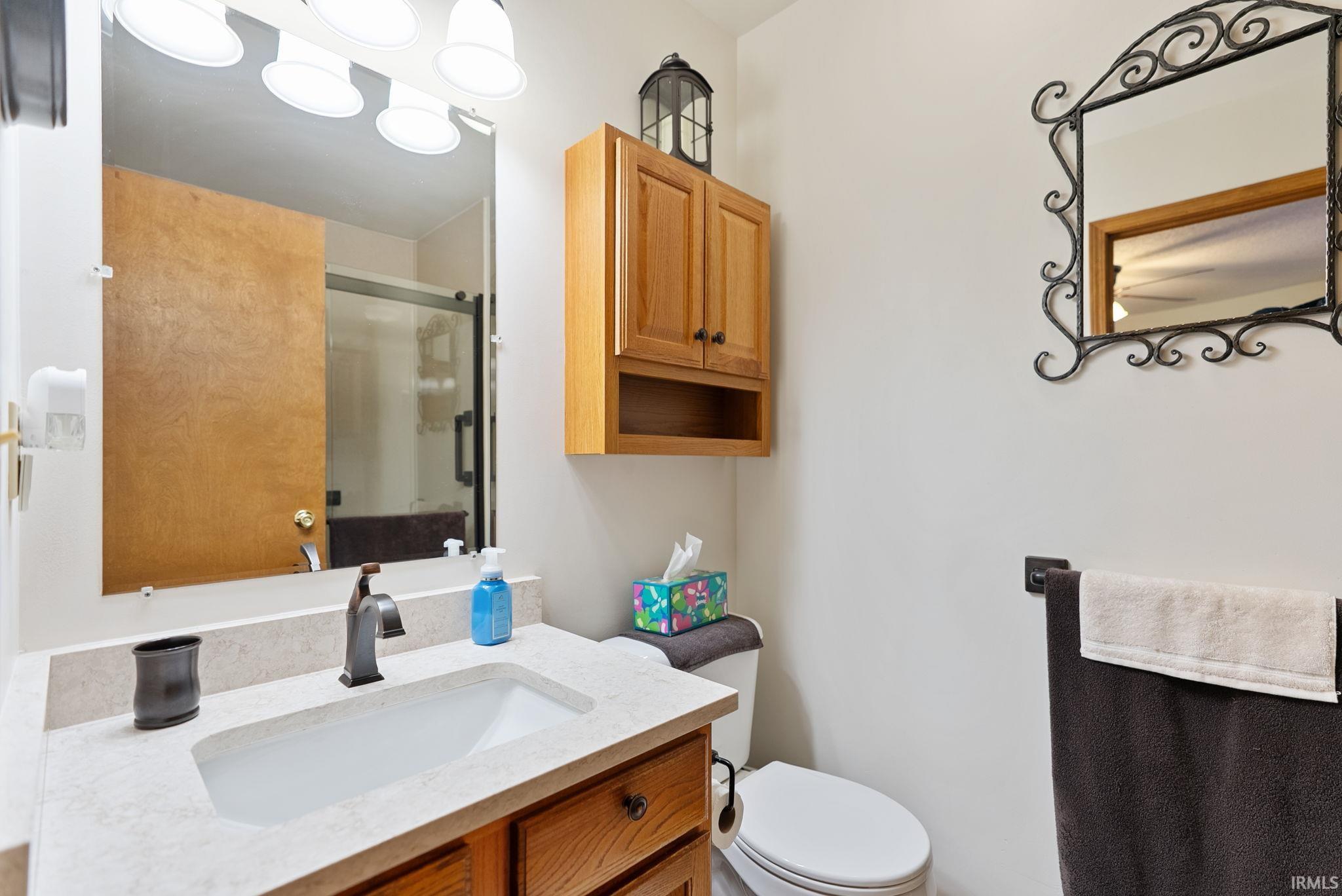 Bathroom vanity with an integrated sink, light-toned countertop, and bronze-finish faucet