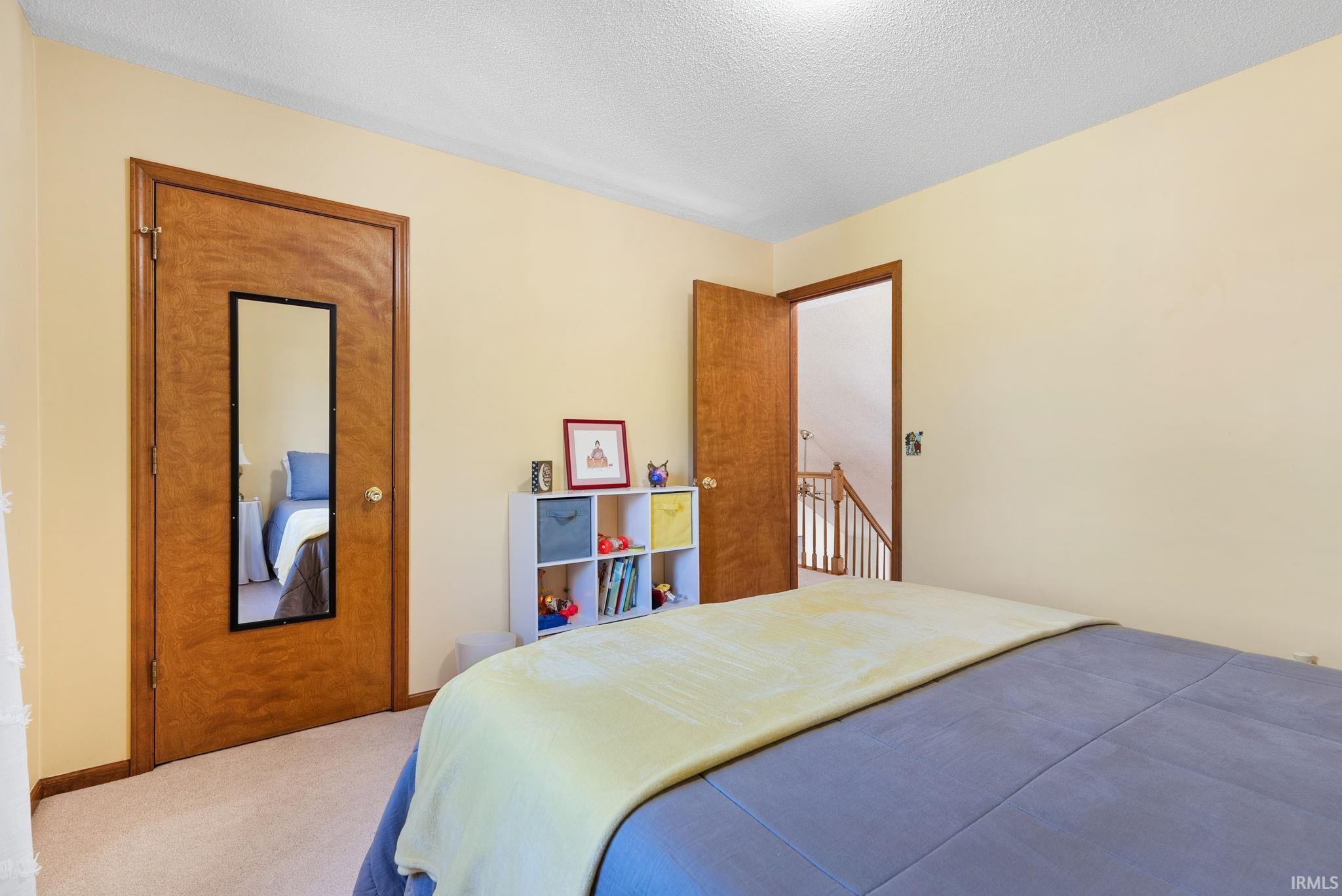 Room with light-toned walls, wood-finish doors, and carpet flooring