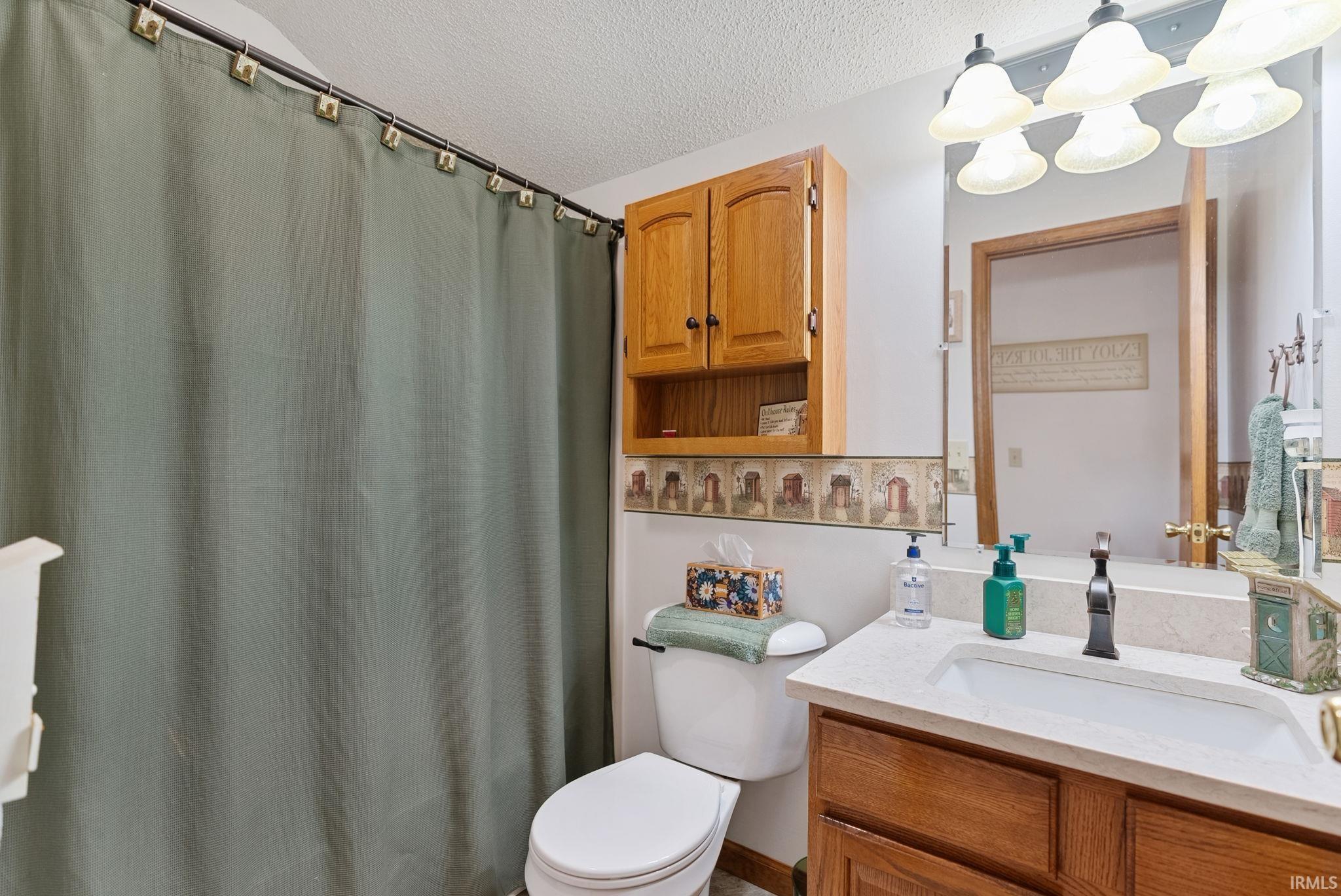 Bathroom featuring a light-toned vanity with an integrated sink, a dark-toned faucet, and a large wall-mounted mirror
