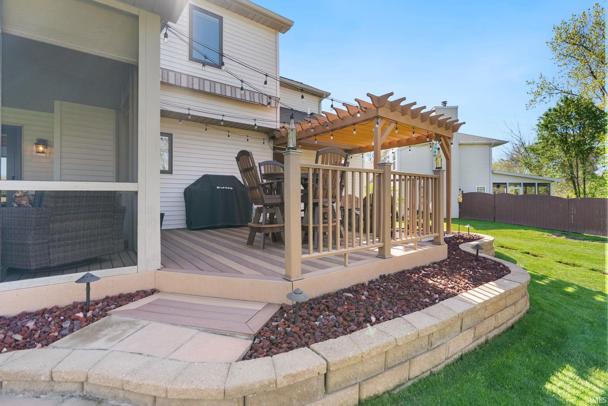 Expansive outdoor living area featuring a multi-level deck, a screened porch, and a pergola-covered section
