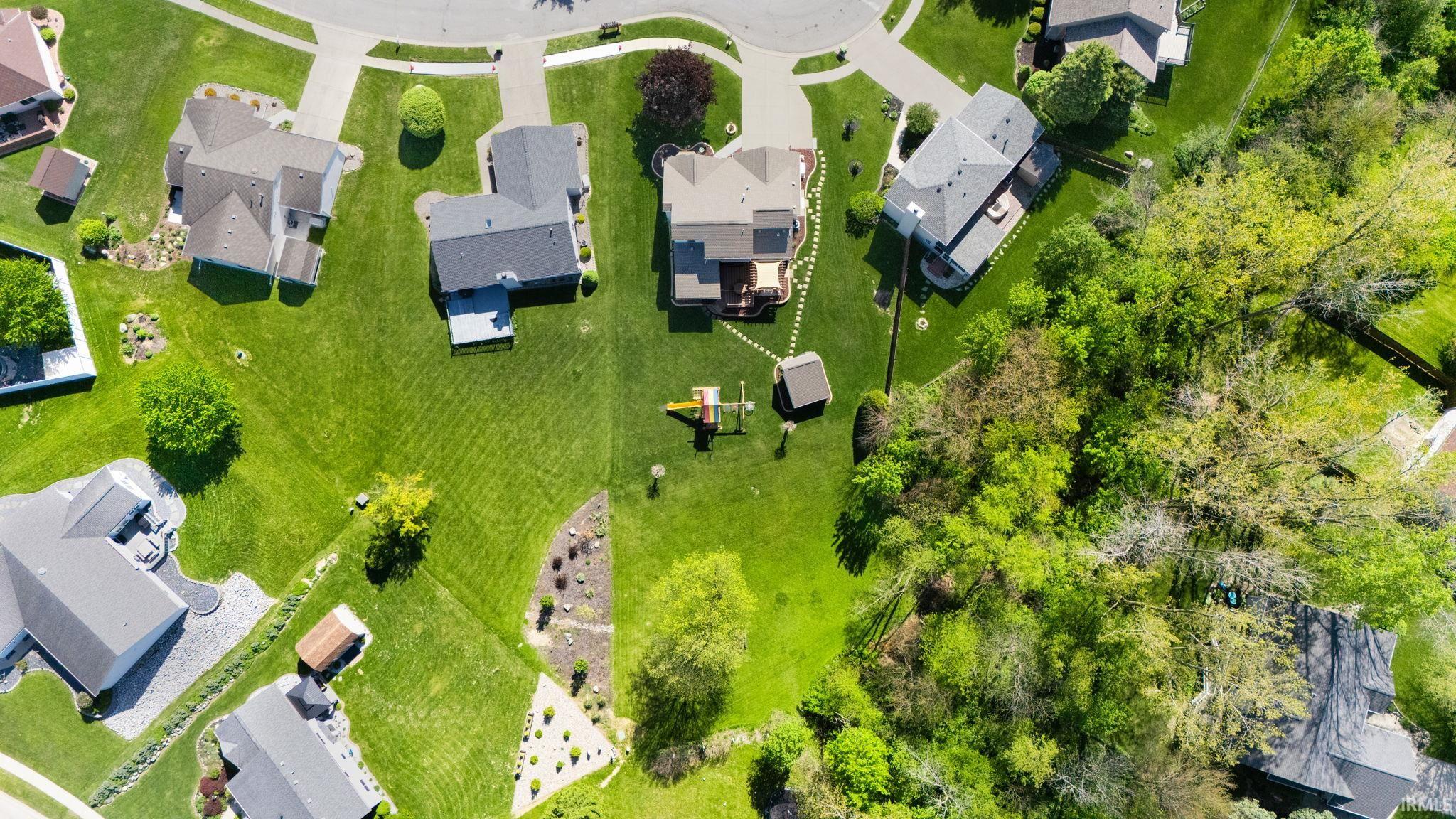 Aerial perspective showcasing multiple properties with expansive green lawns