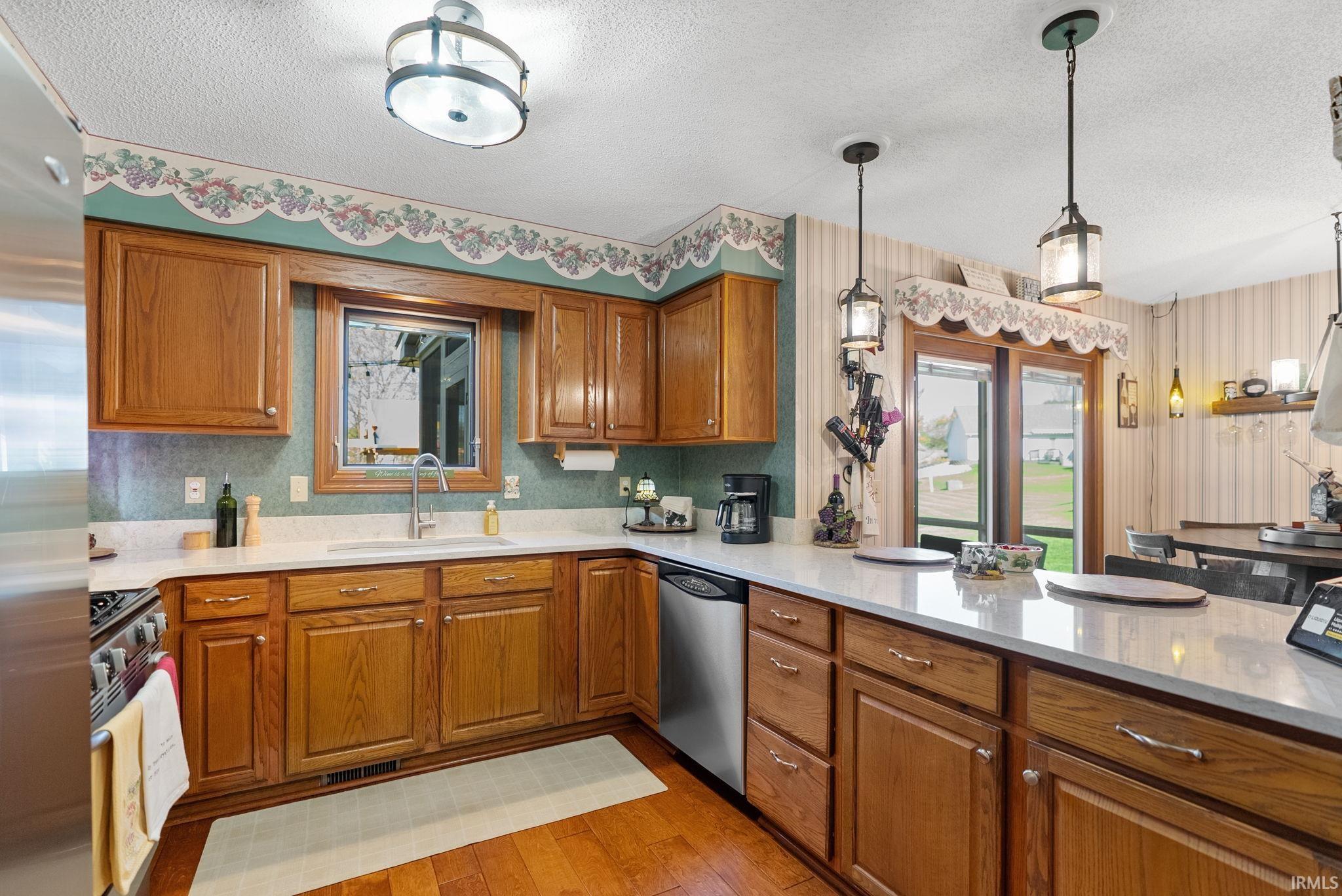 Kitchen featuring wood-finish cabinetry, light-toned countertops, and wood-finish flooring