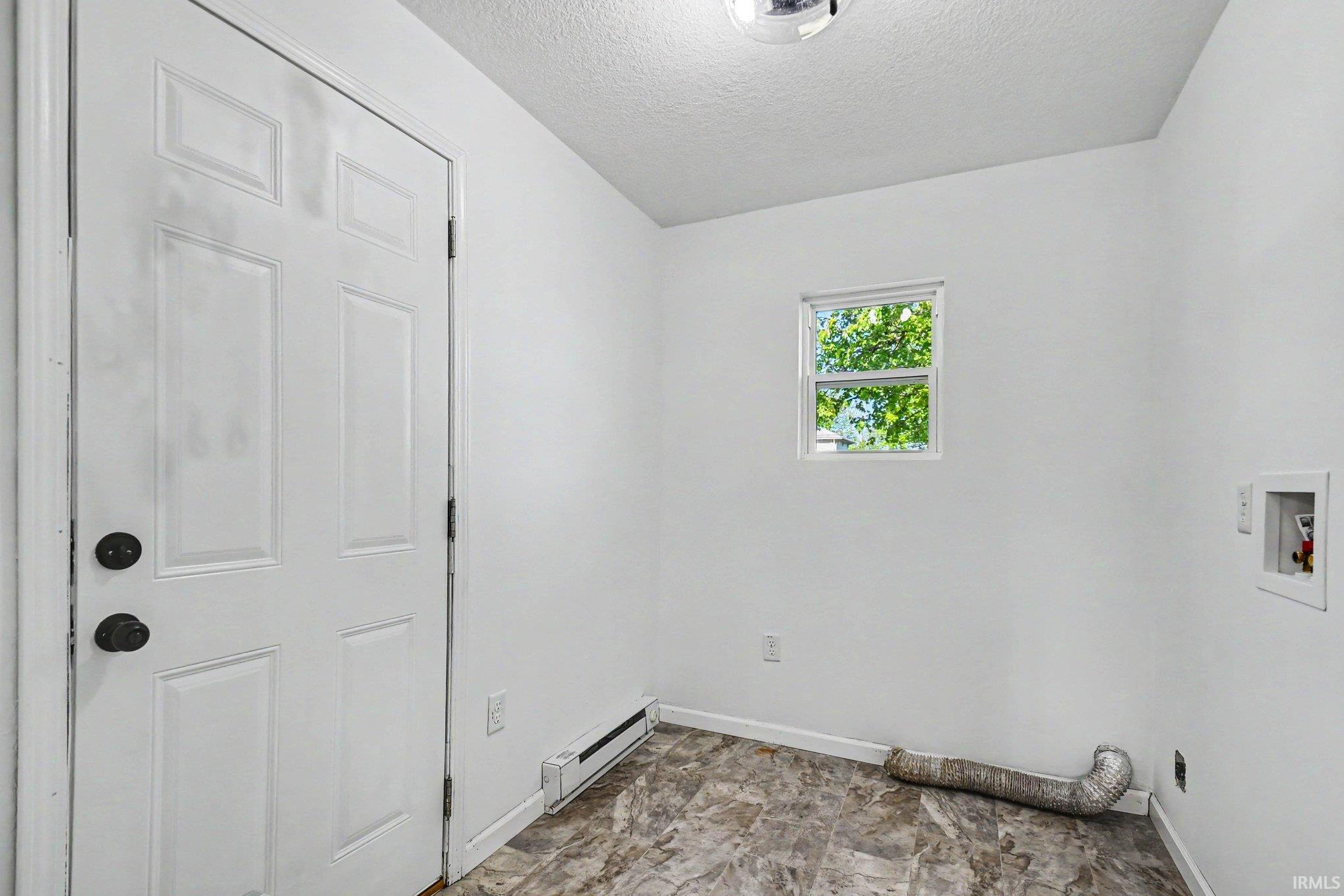 Main Floor Laundry Room Off Kitchen with Door to Back Deck and Fenced-In Yard