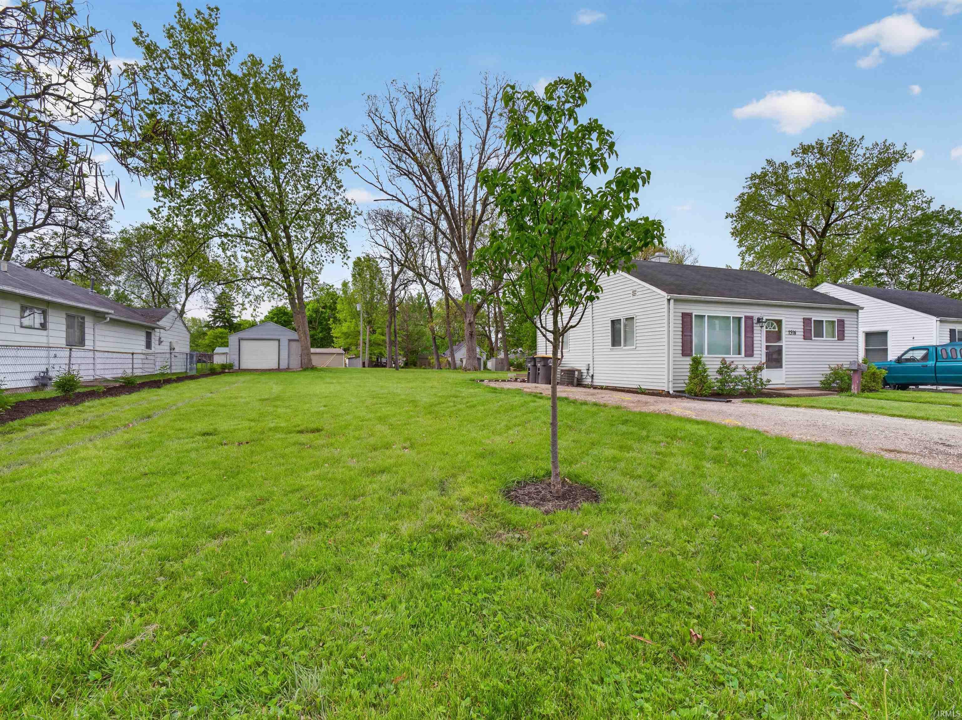 Expansive grassy yard with mature trees