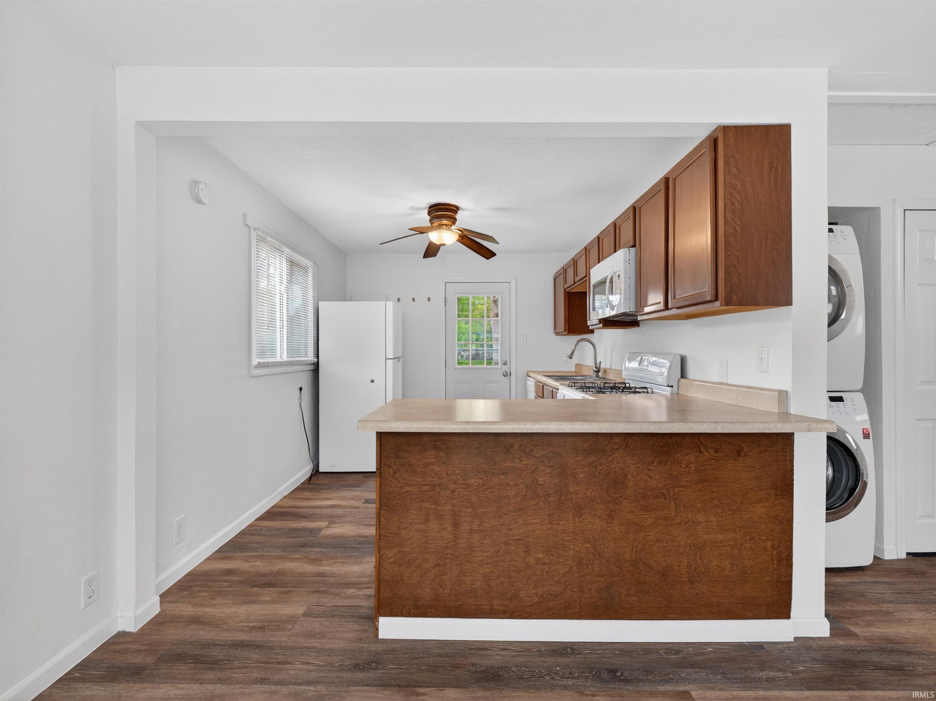 Kitchen featuring wood-finish flooring, white walls, and a light-colored countertop