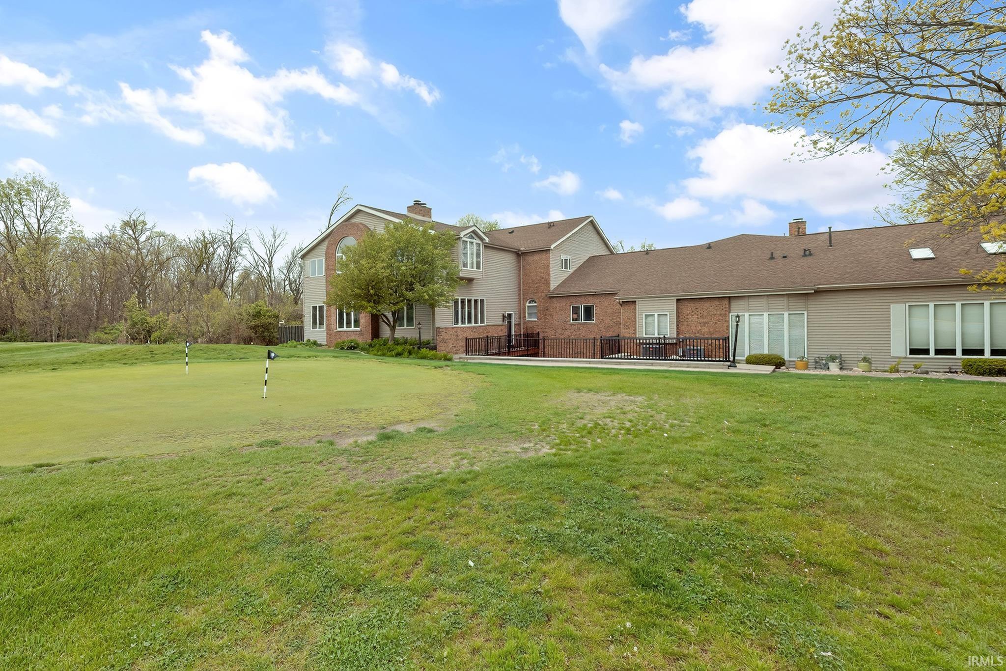 Expansive green lawn with a private putting green featuring two flagsticks