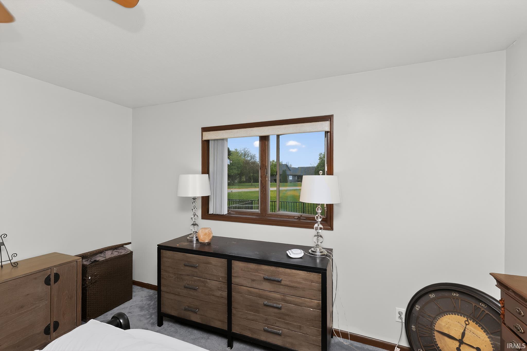 Window with wood trim, light gray walls, and gray carpeting