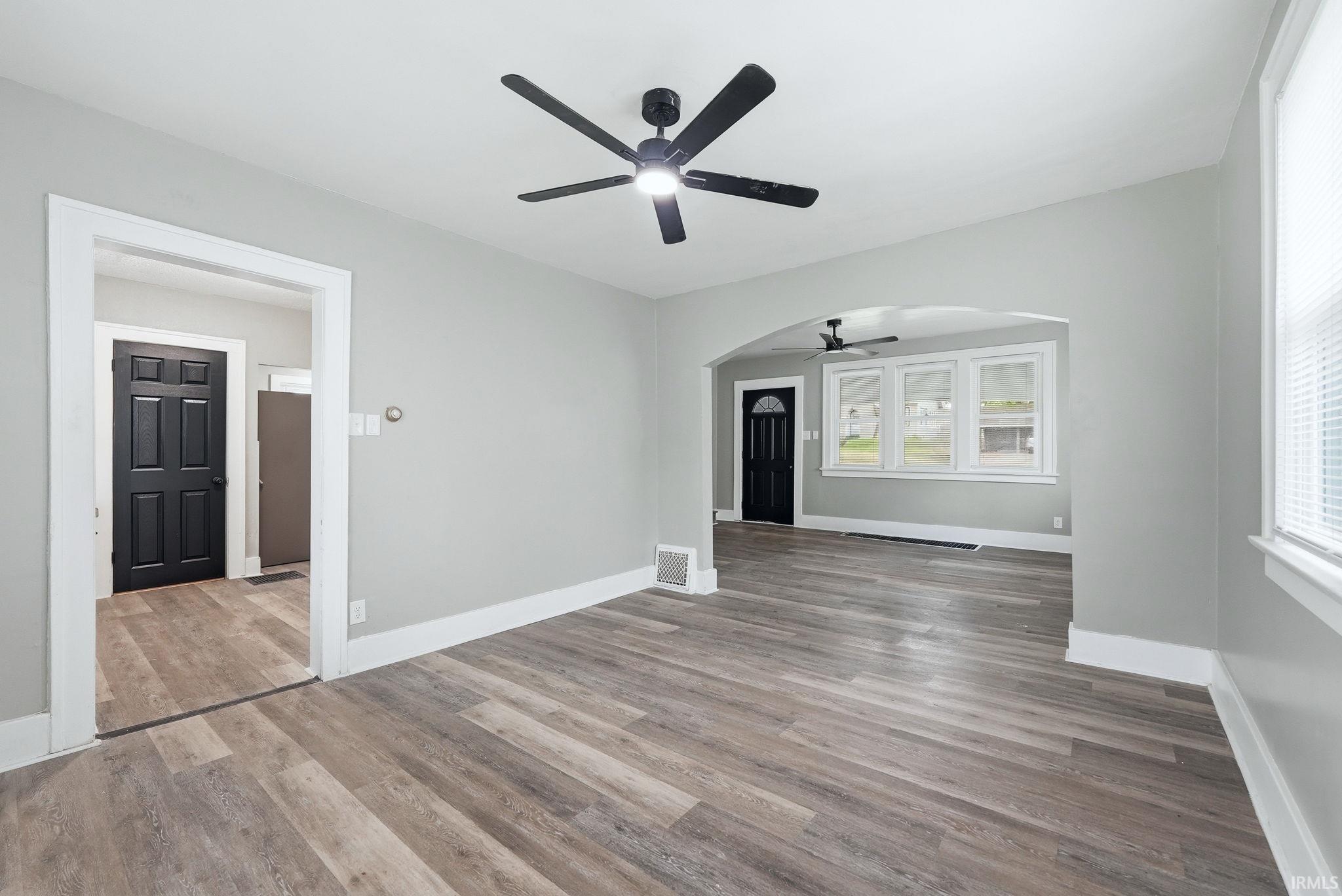 Interior space featuring wood-finish flooring, light gray wall paint, and white trim