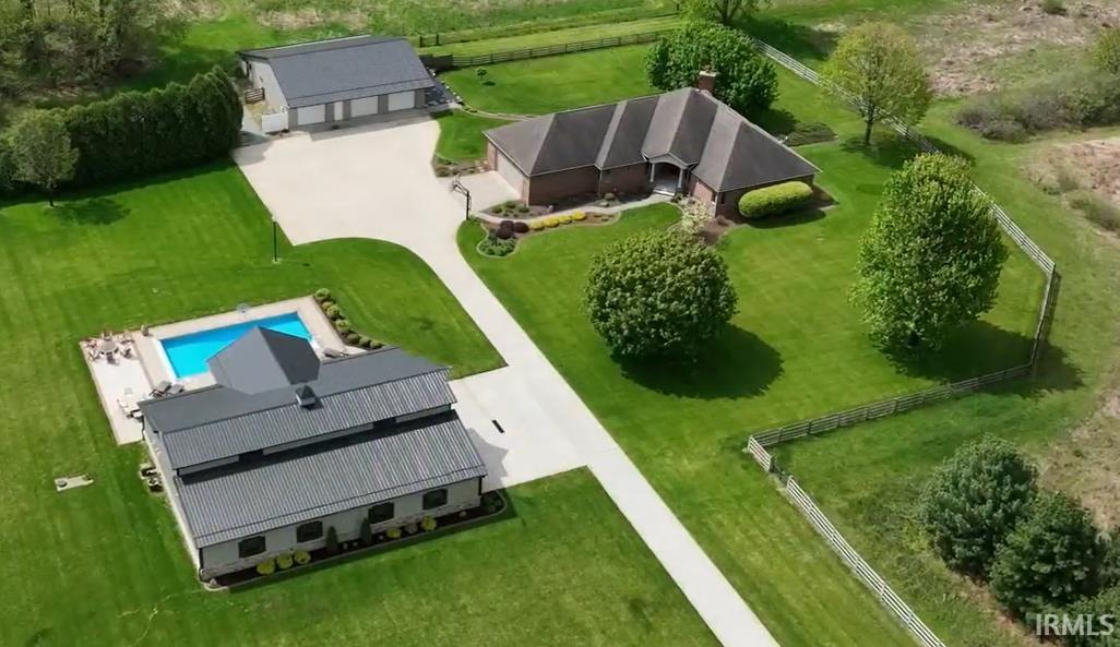 Expansive property featuring a main residence, a separate auxiliary structure with a pool, and a detached three-car garage